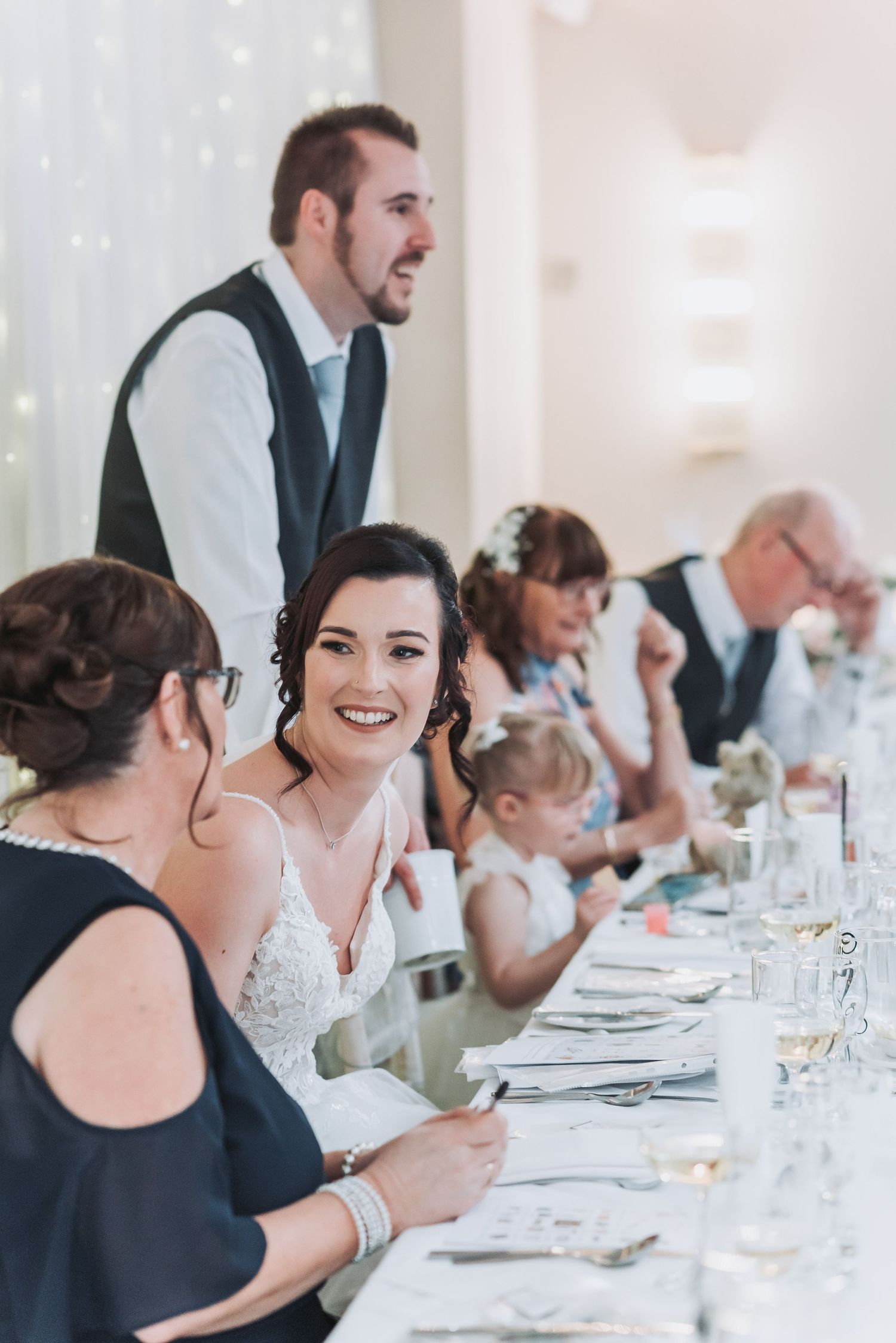 Wedding reception guests gather at an elegantly set table for dinner celebrations.