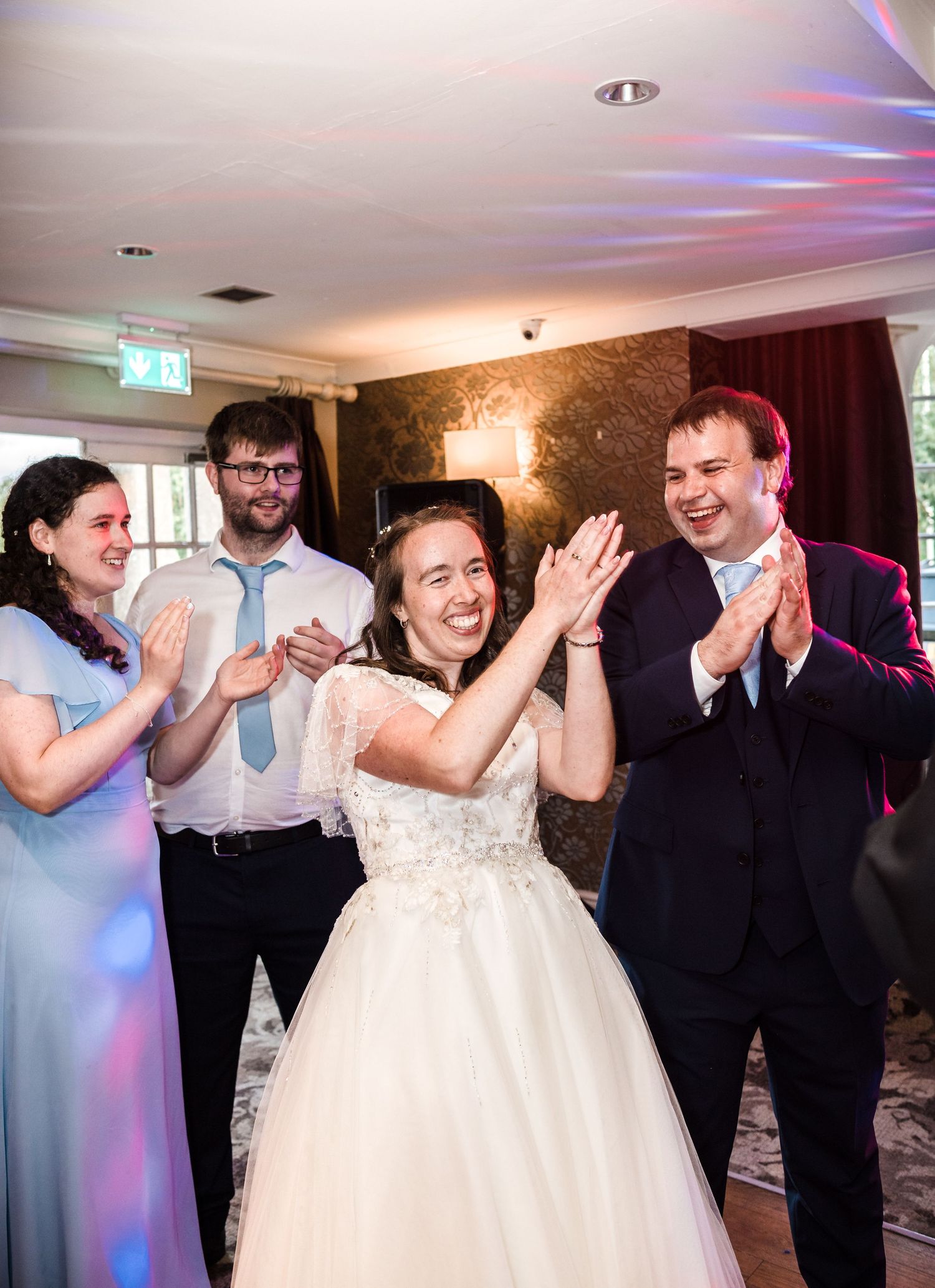 Wedding celebration with guests clapping and celebrating during reception party.