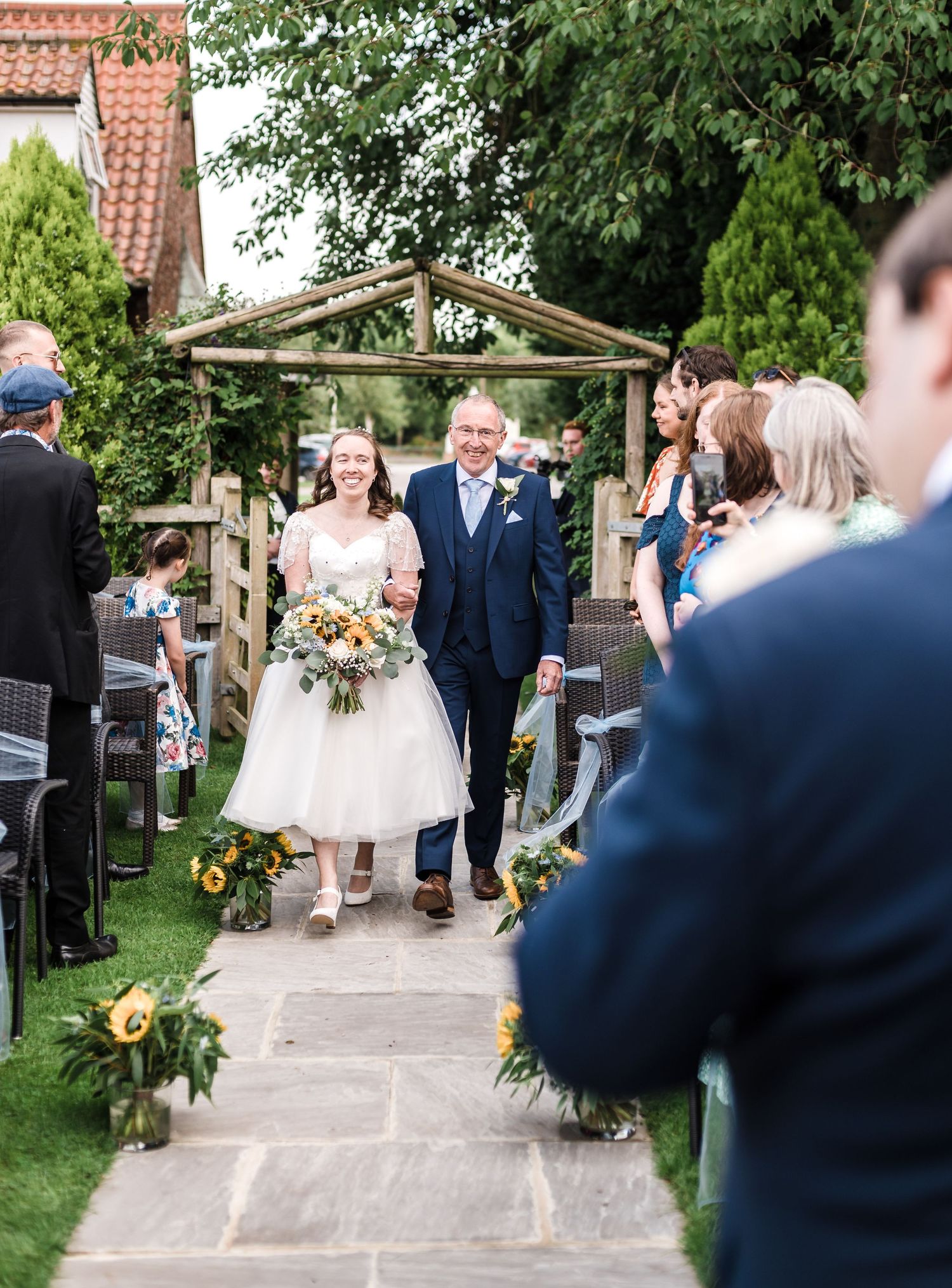 Wedding ceremony in progress at outdoor garden venue.