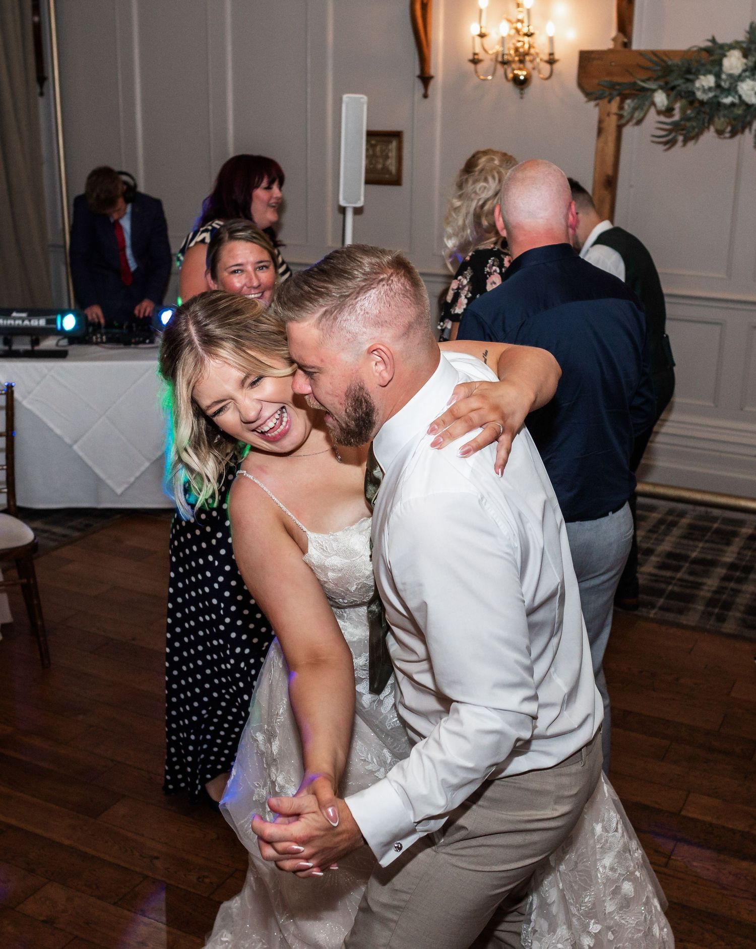 Couples dancing and laughing together during a joyful wedding reception celebration.