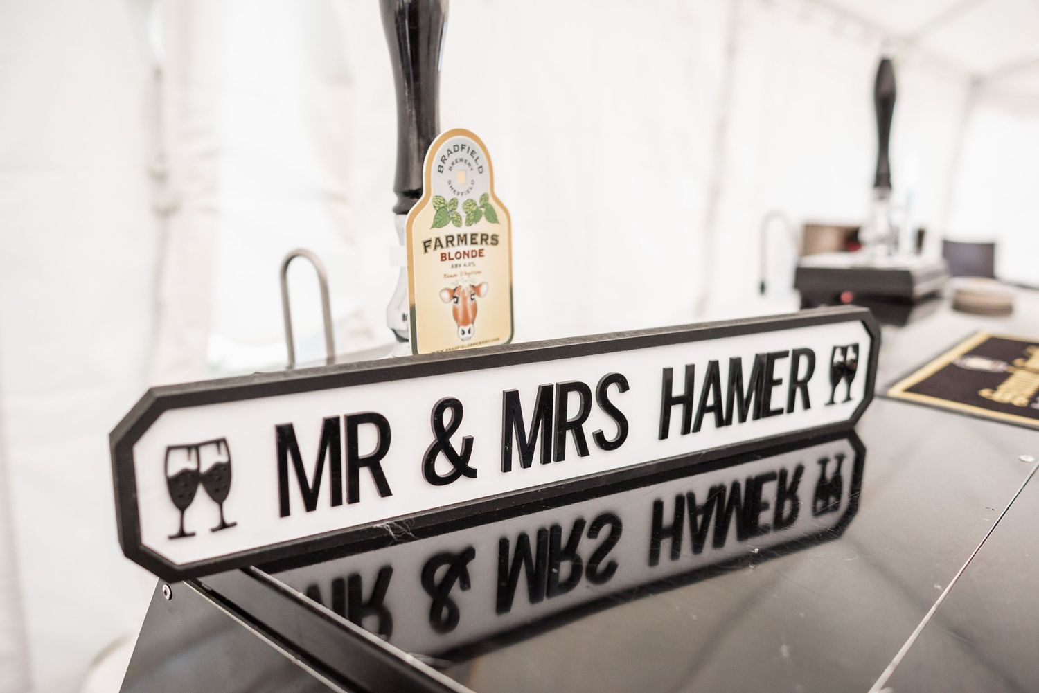 Wedding reception decor featuring a custom street sign style nameplate for Mr & Mrs Hamer.