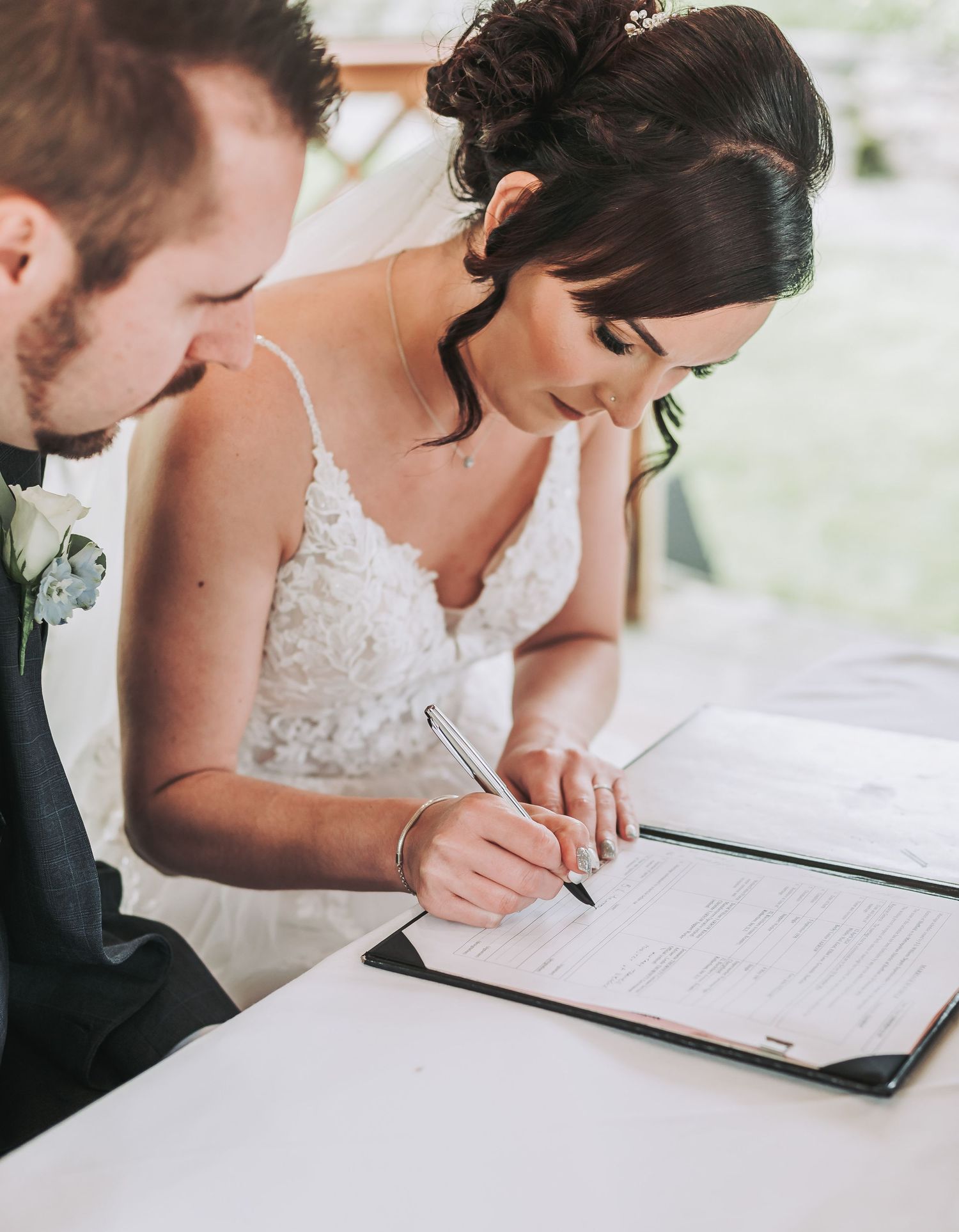 Signing of marriage documents during a wedding ceremony.
