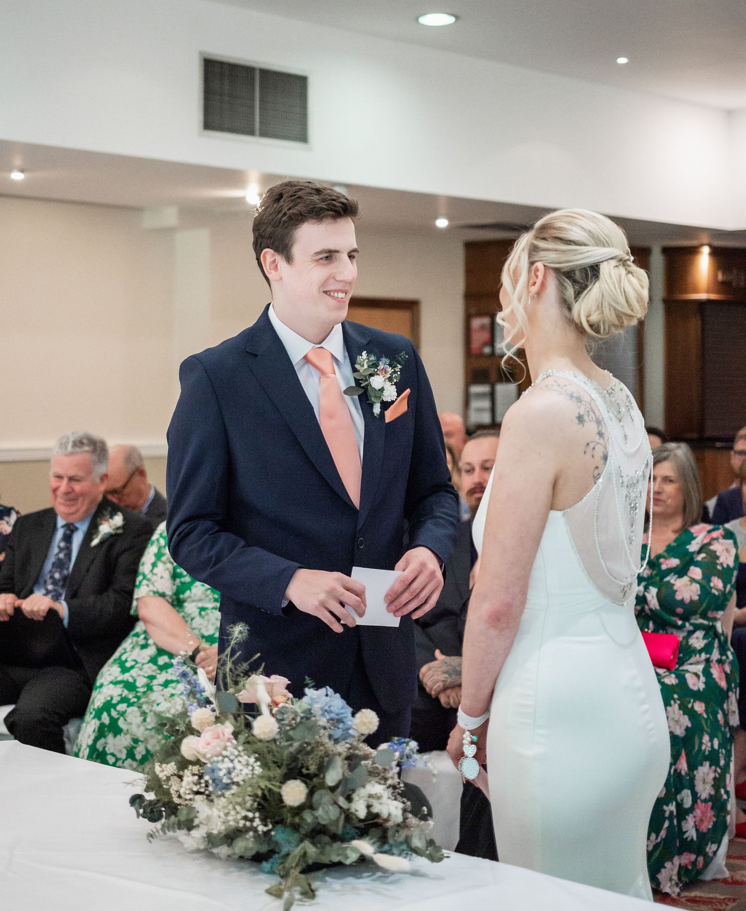 A joyful wedding ceremony moment with elegant floral arrangements on the table.