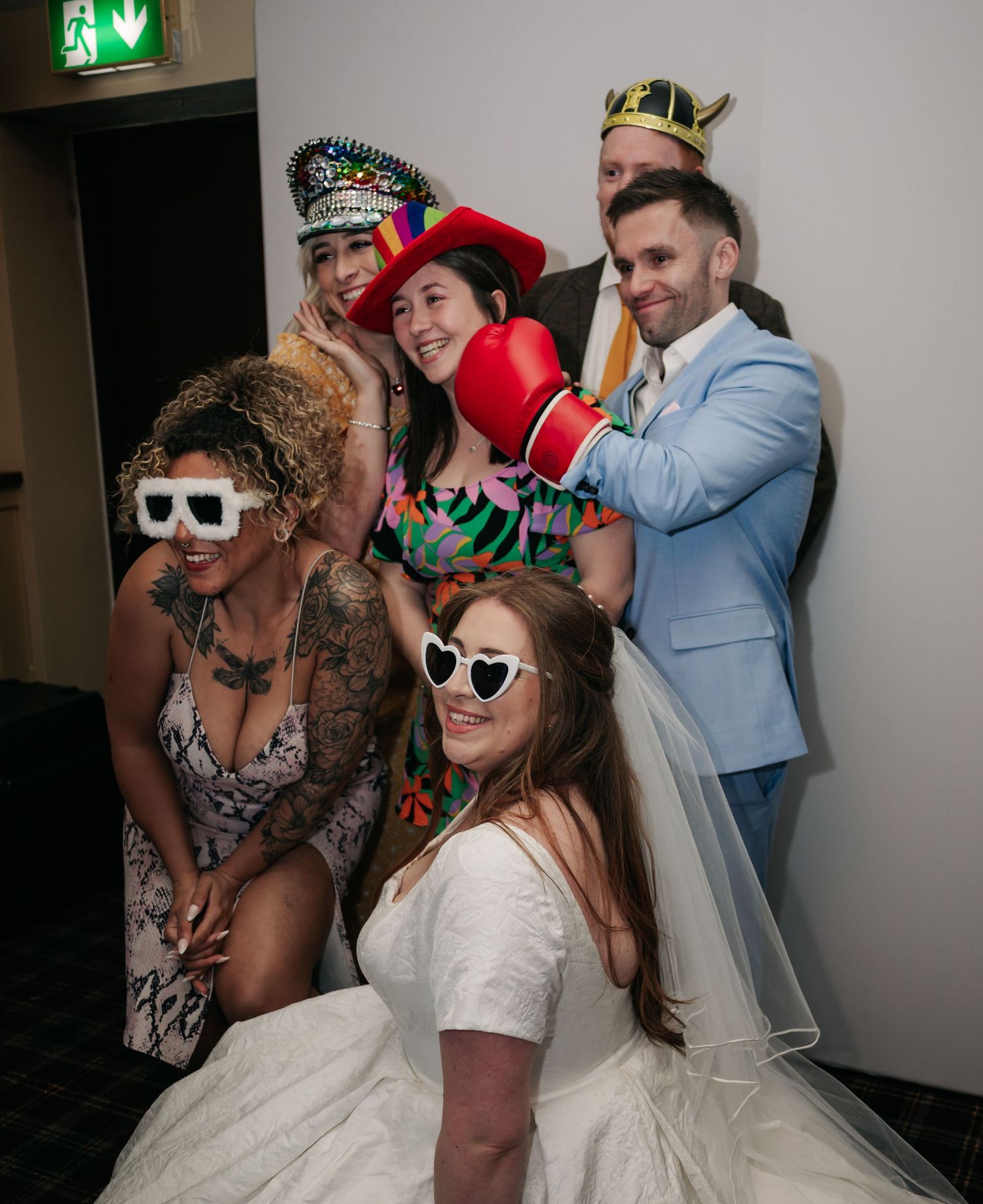 Wedding party guests pose wearing fun party props and sunglasses during reception celebrations.
