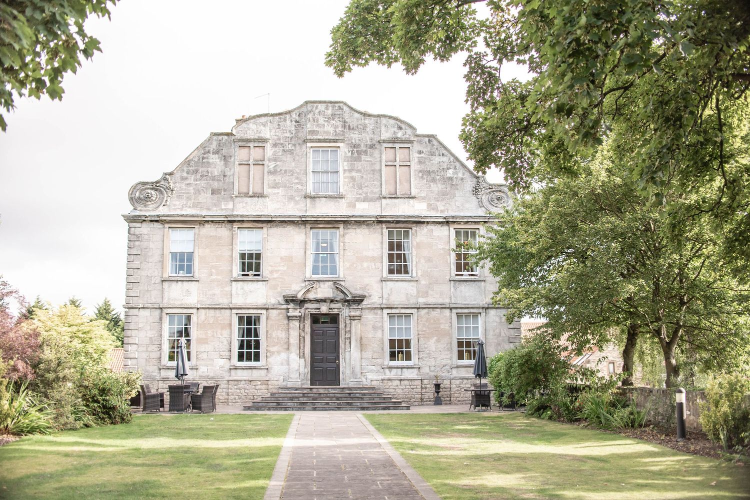 Elegant historic stone mansion with symmetrical architecture and manicured grounds.