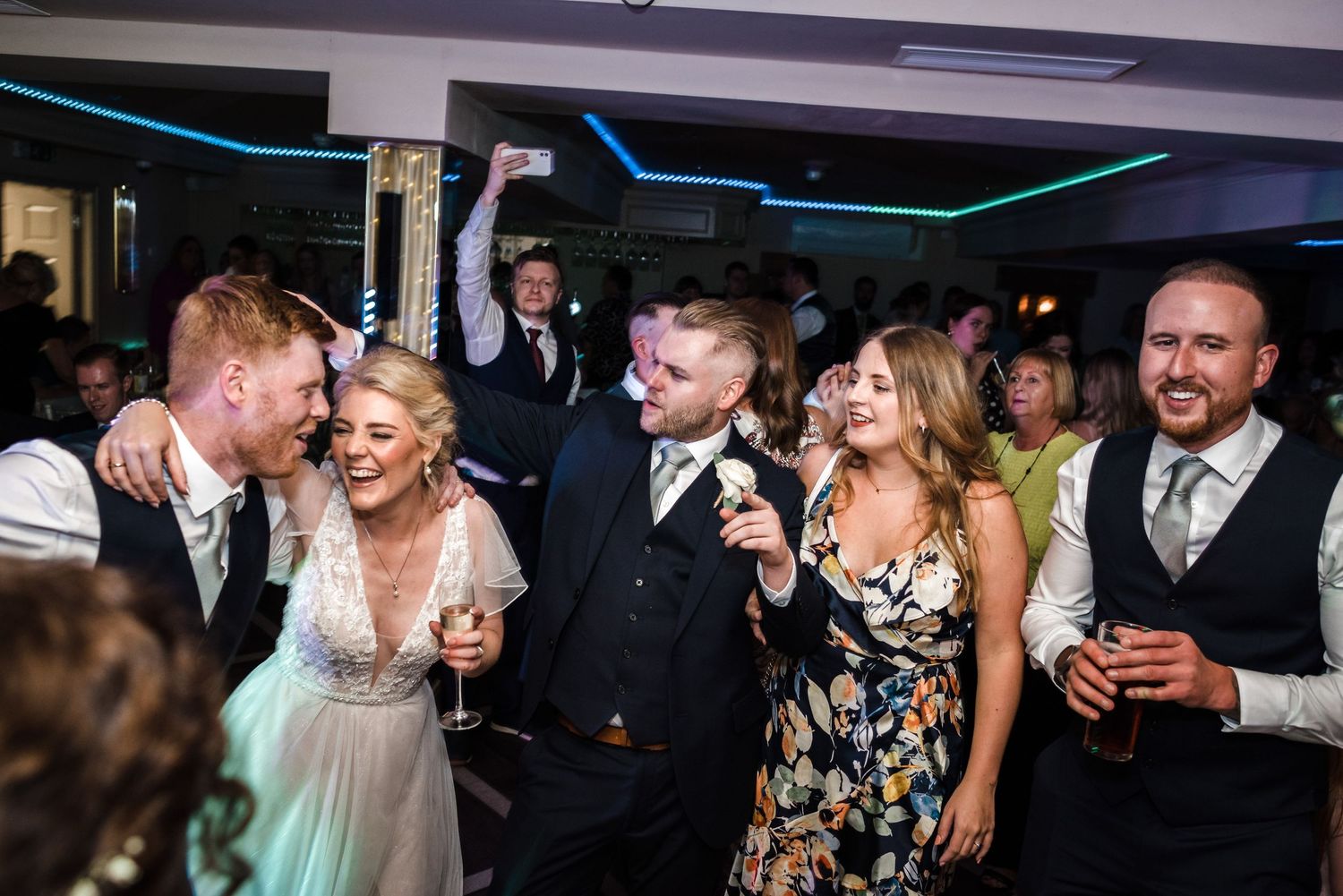 Wedding guests enjoying a lively celebration on the dance floor.