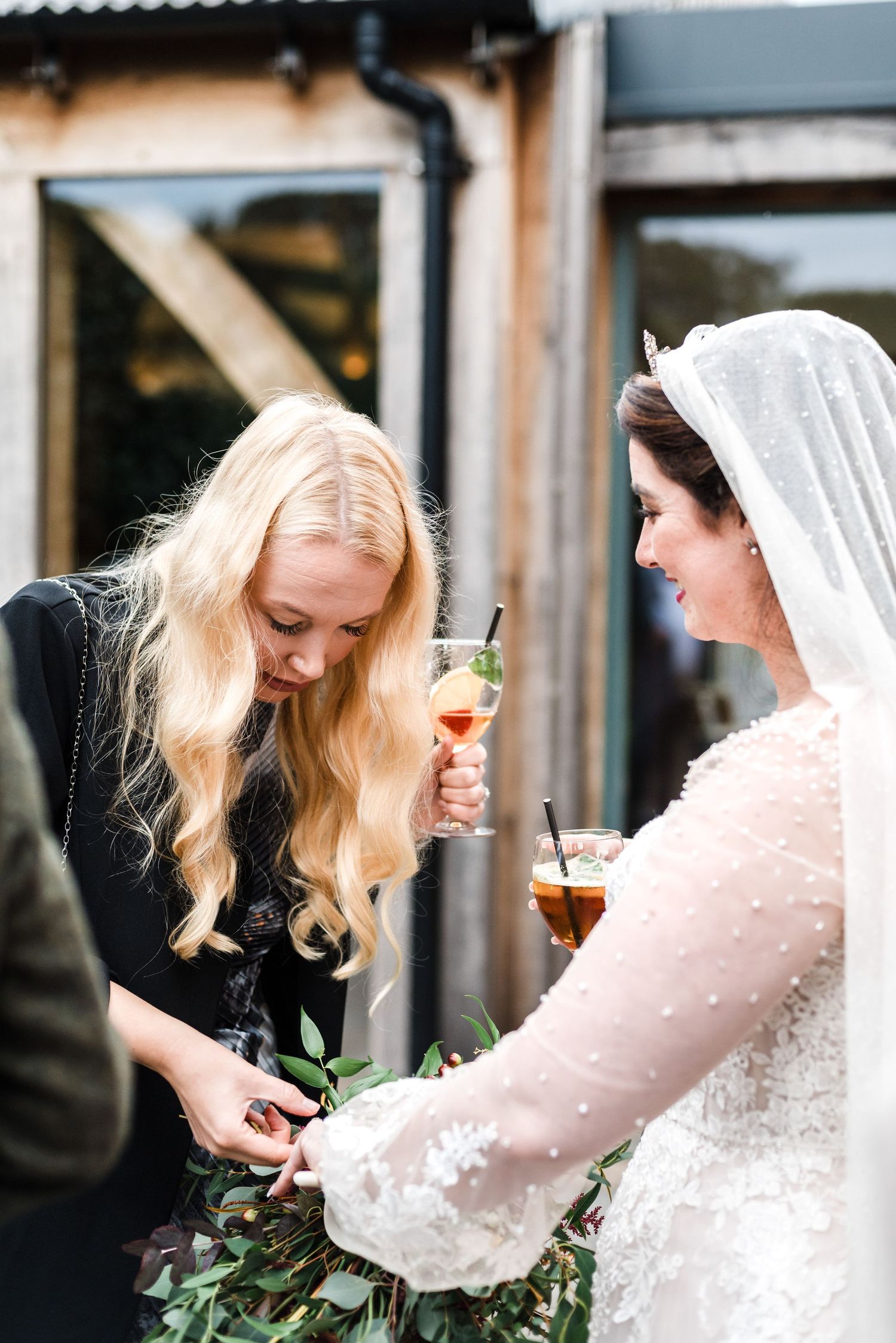 Wedding celebration outdoors with drinks and floral arrangements.