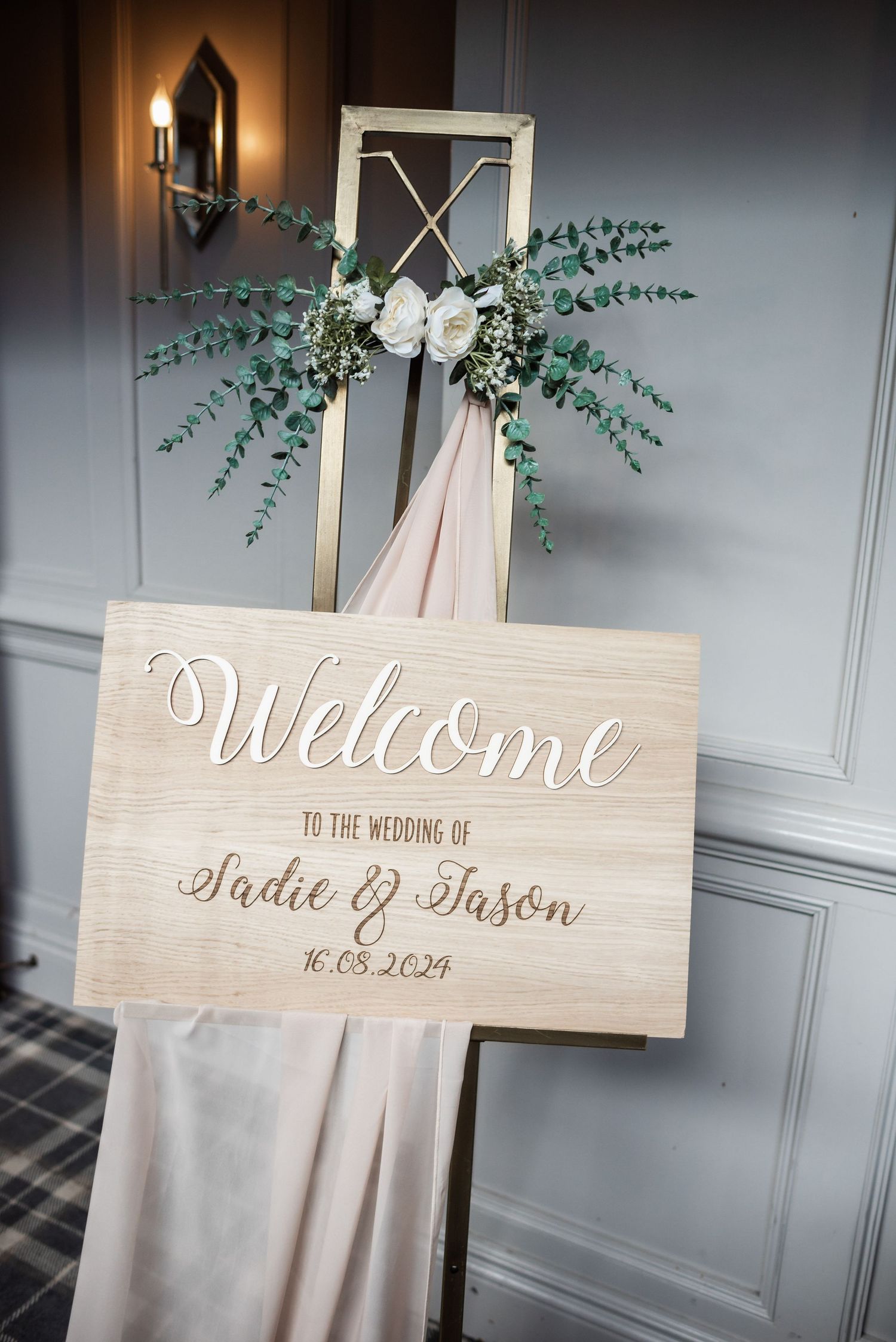 Wooden welcome sign with eucalyptus decor for Sadie & Jason's wedding.
