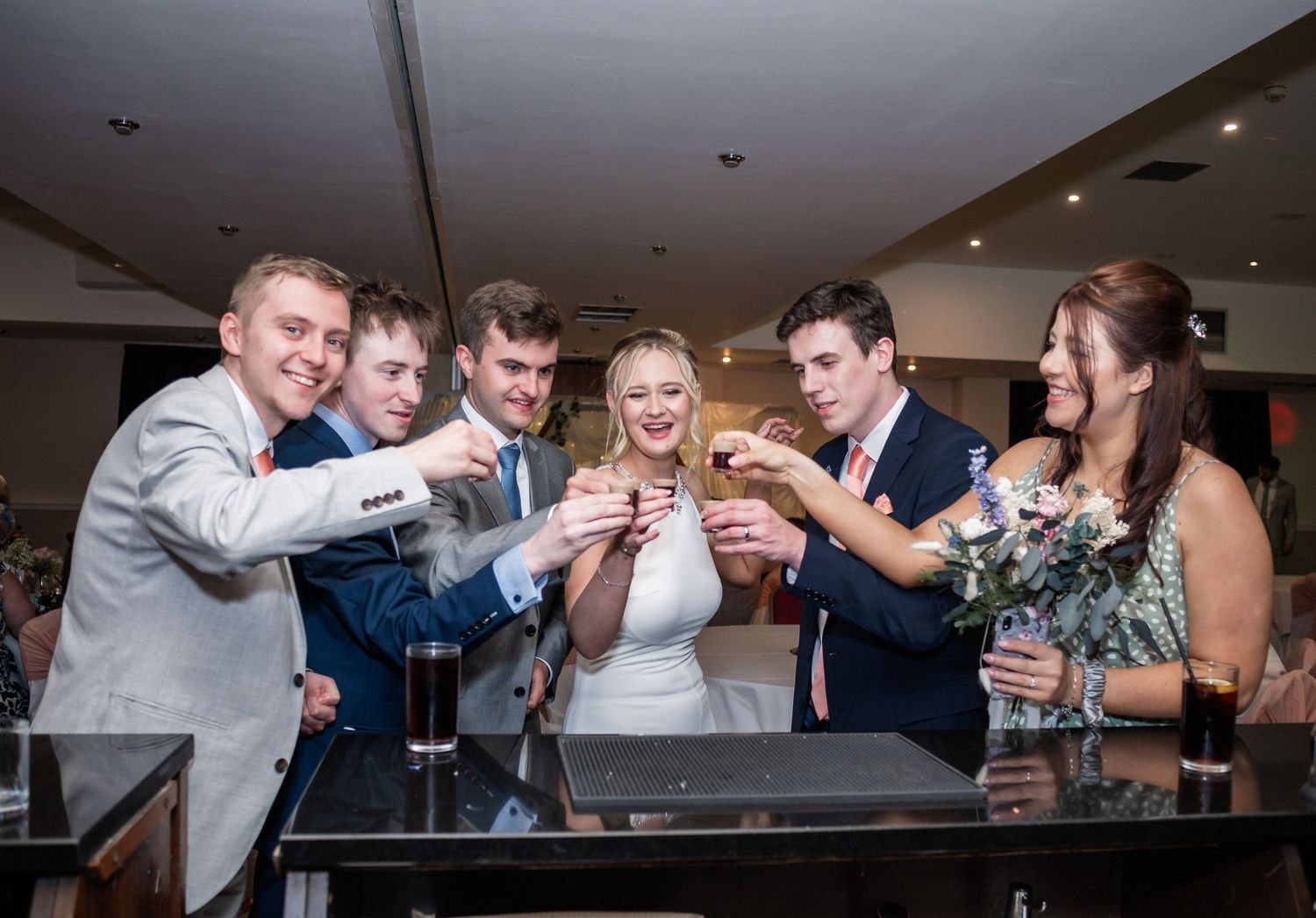 Wedding party toasts with drinks at reception celebration gathering.