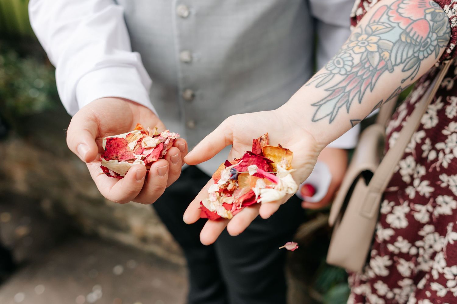 Close-up of hands exchanging small items during wedding ceremony.