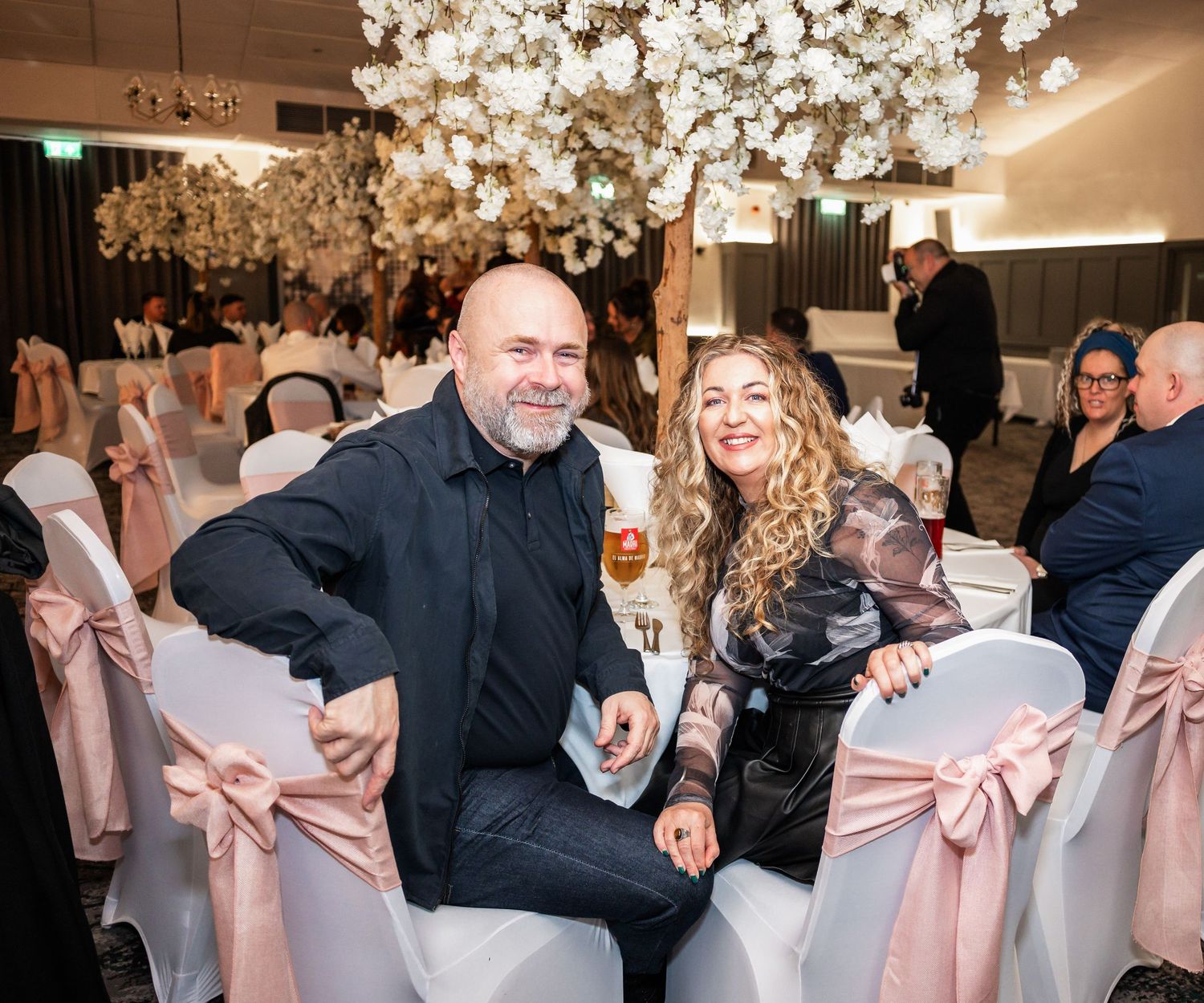 Wedding reception guests enjoying themselves at a beautifully decorated venue with floral ceiling installations.