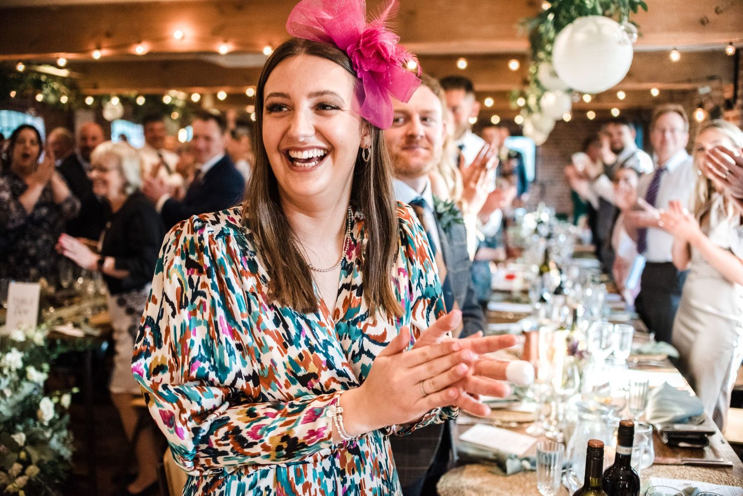 Joyful wedding reception scene with celebratory atmosphere in rustic venue with string lights.