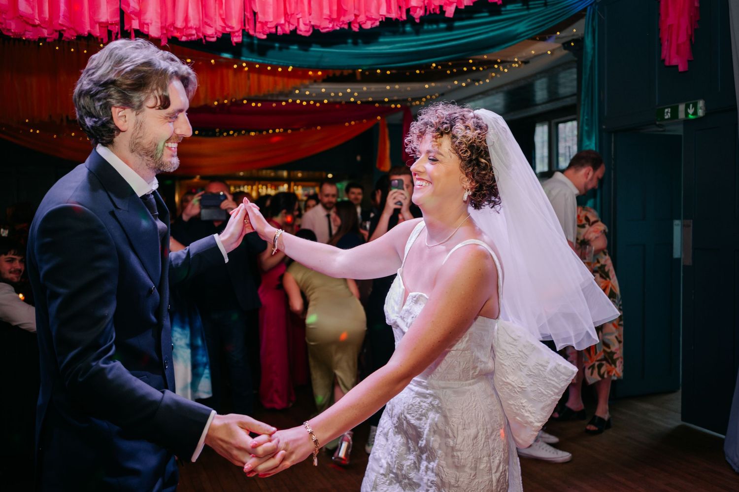 Wedding dance celebration under warm lighting and festive decorations.