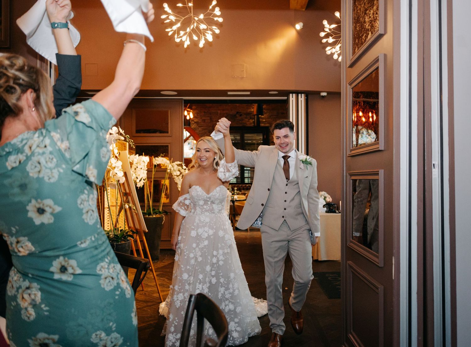 Wedding reception venue with decorative lights and guests dancing in formal attire.