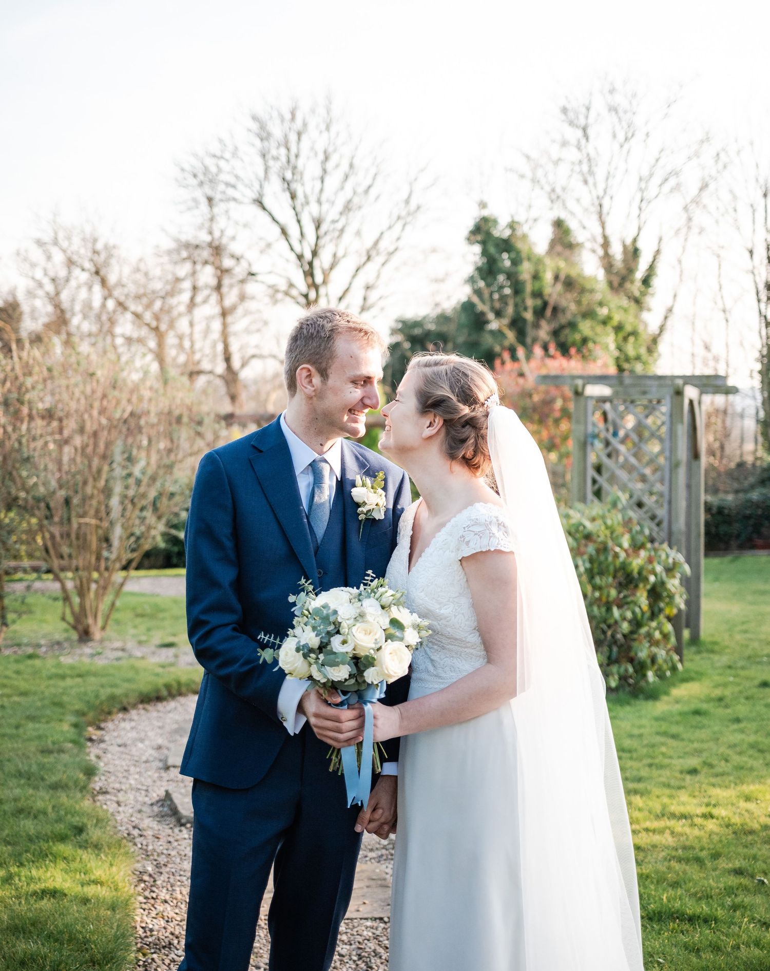 Bride and groom share tender moments in garden setting during spring wedding.