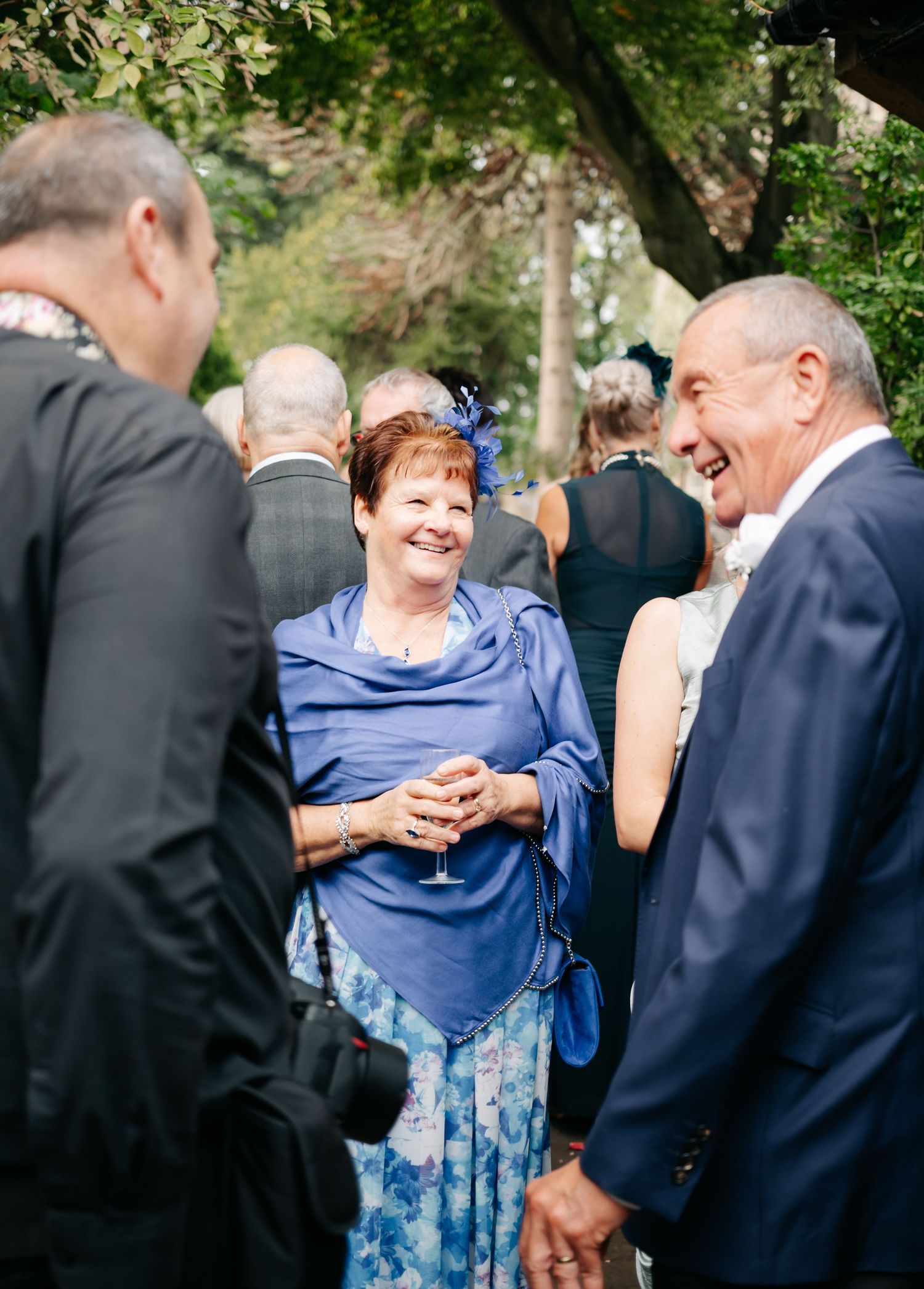 Wedding guests enjoying conversation during an outdoor reception.