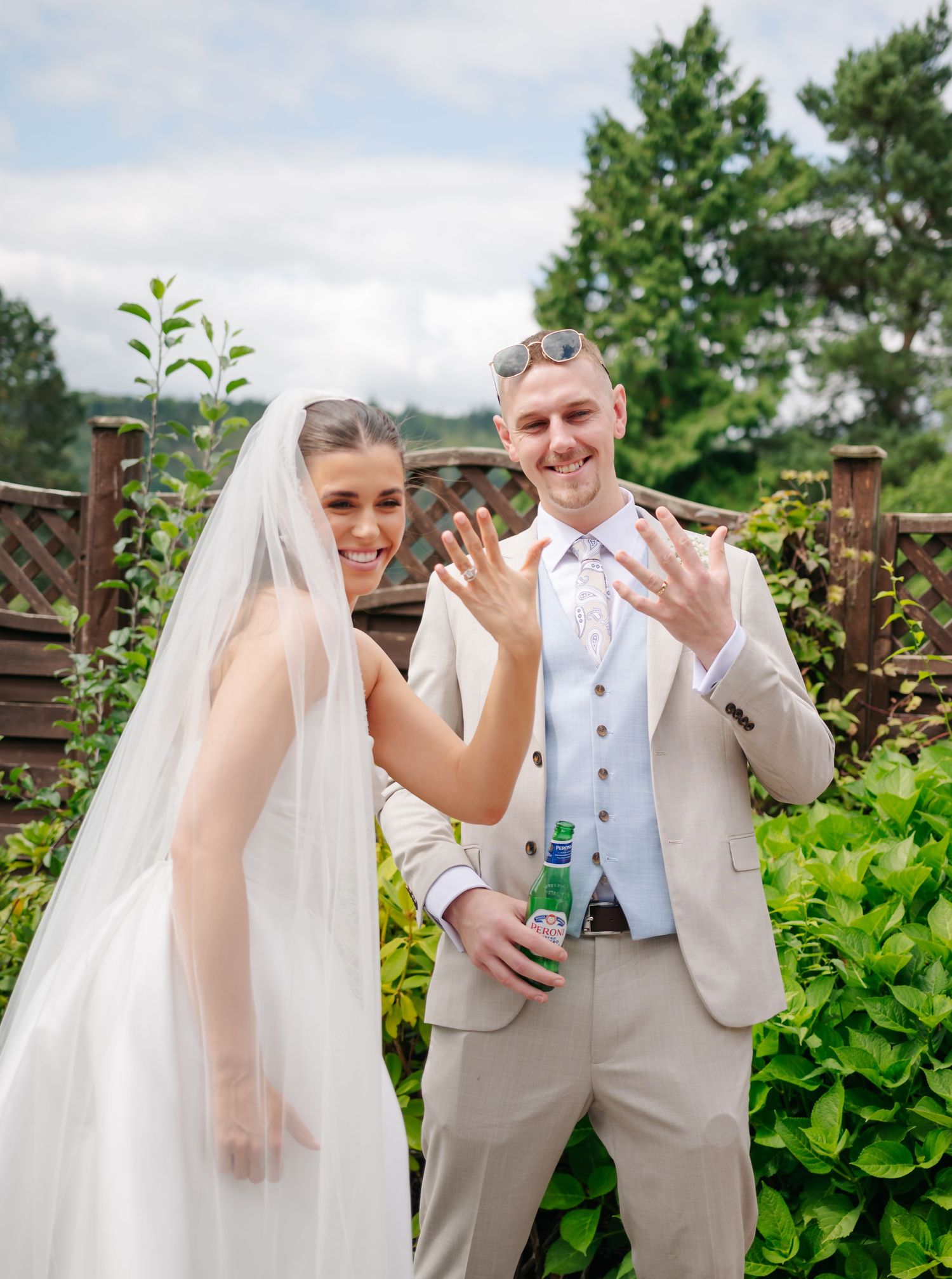 Playful outdoor wedding sequence with couple in light-colored attire against green foliage.