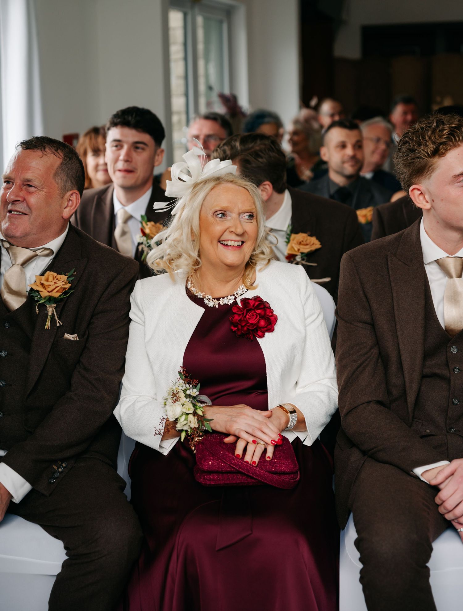 Wedding guests in formal attire laughing and enjoying themselves during a reception celebration.