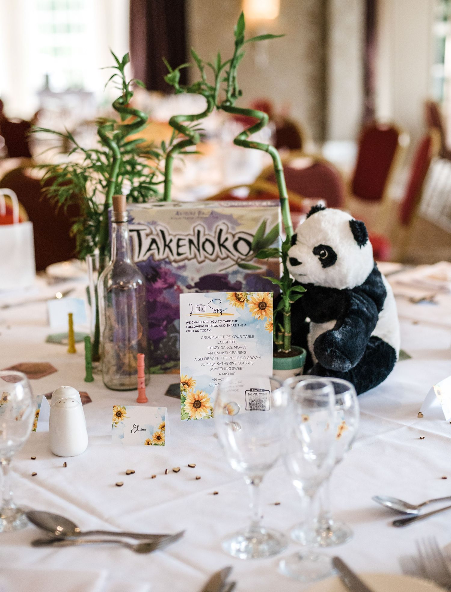 Wedding reception table decorated with panda plush toy and bamboo centerpiece.