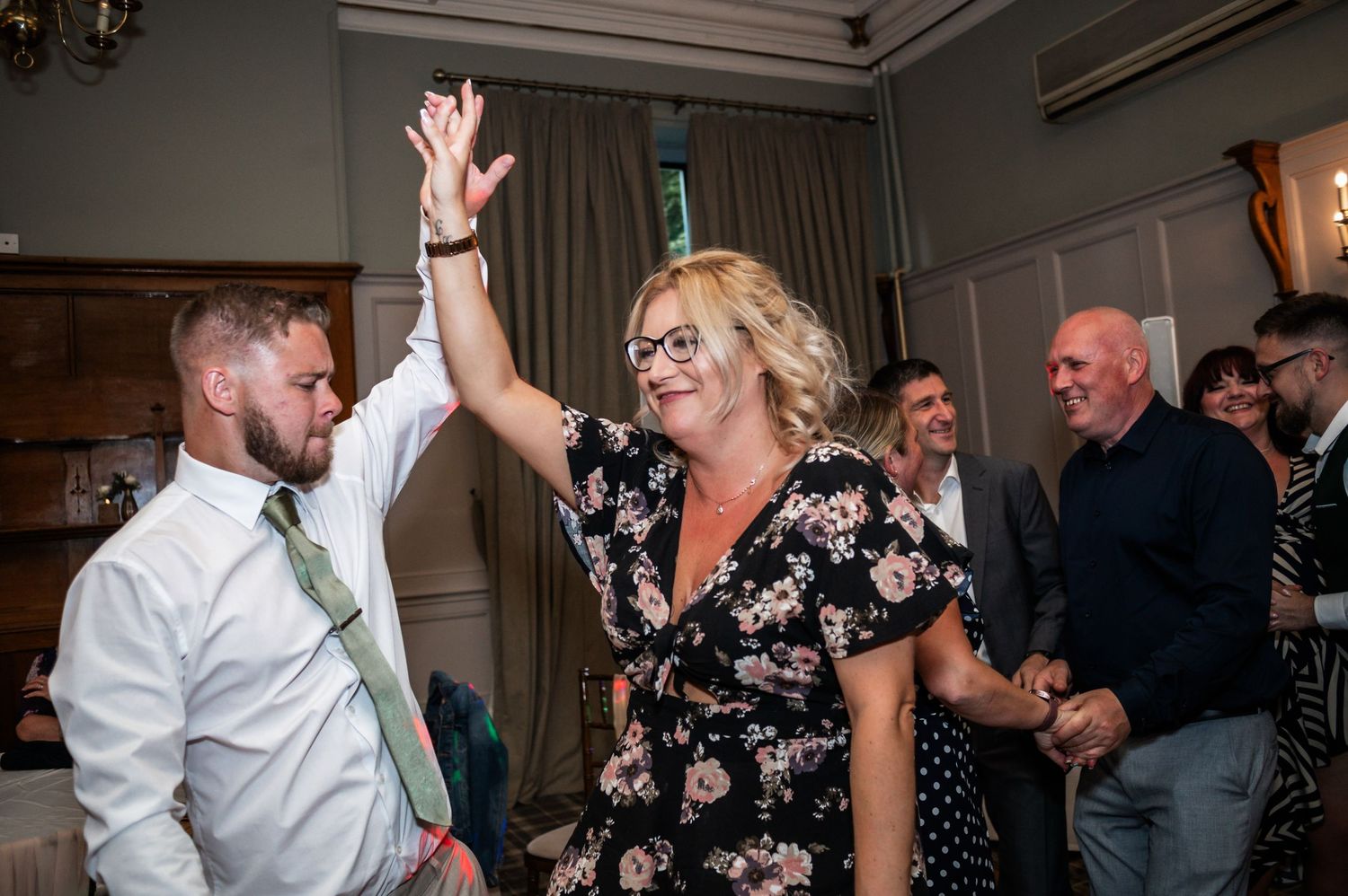 Wedding guests dancing and celebrating during a lively reception party.