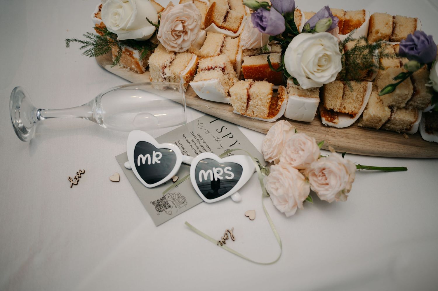 Wedding decorations with 'Mr & Mrs' heart signs and roses next to a champagne glass.