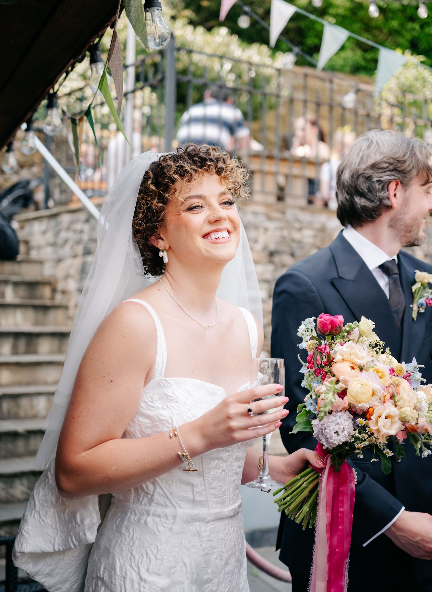 A joyful wedding celebration with colorful flowers and white bunting decorations.