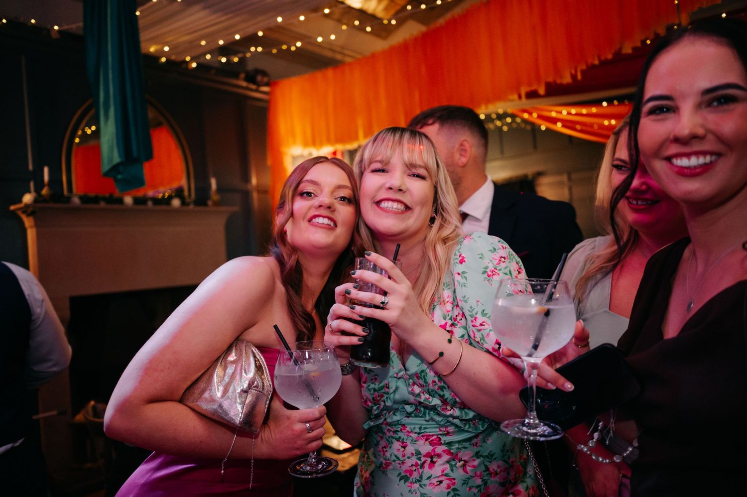 Wedding reception party guests celebrating under warm lighting.