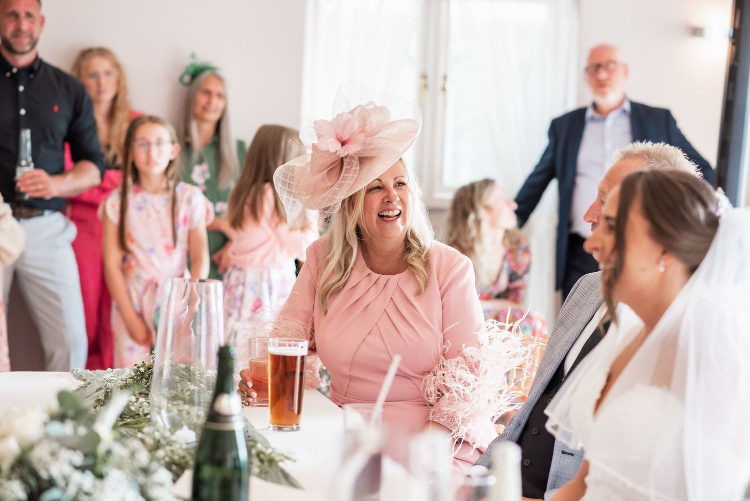 Wedding reception guests enjoying celebratory drinks and laughter.