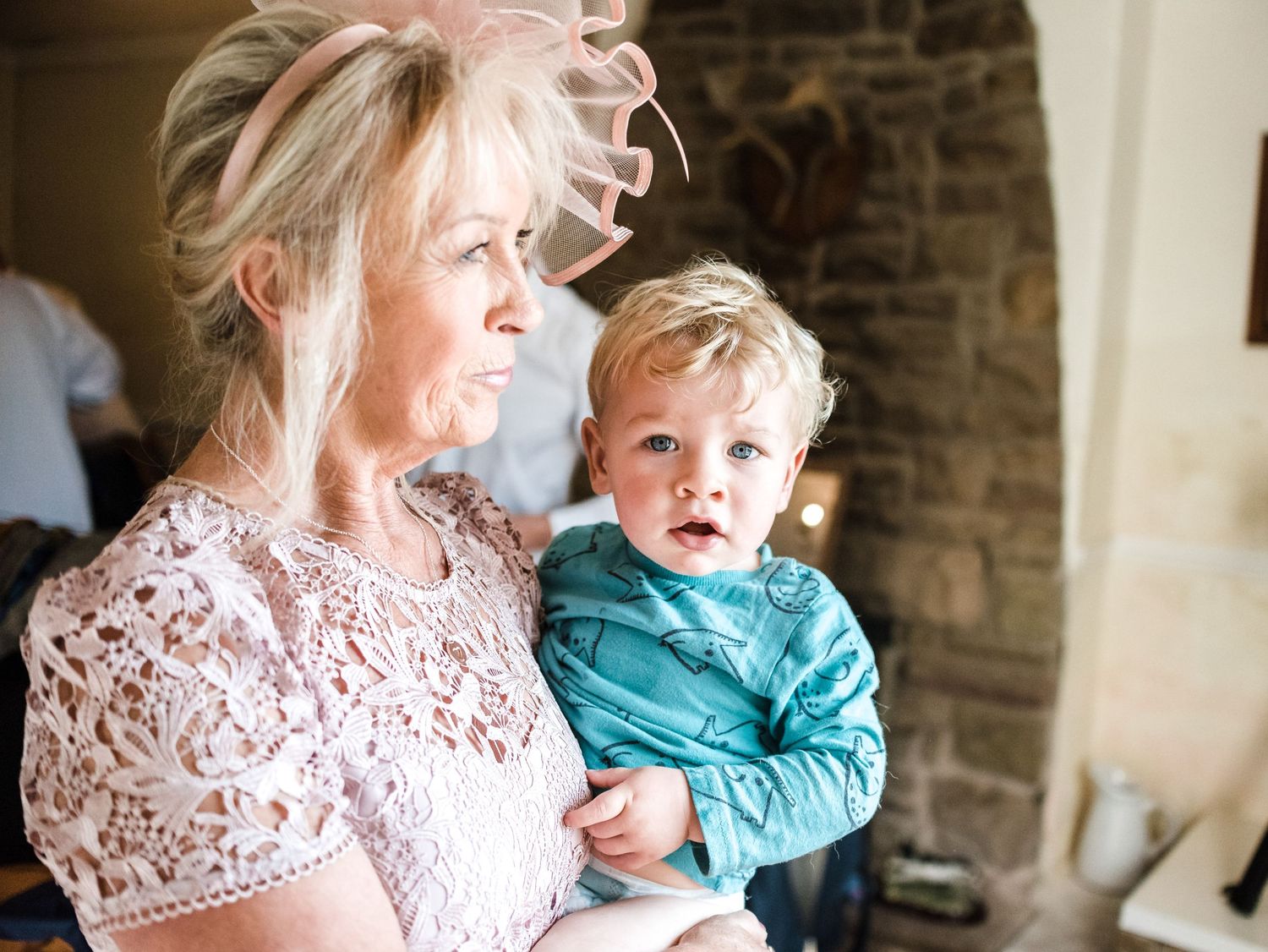 Sweet candid moment during wedding preparations with small child in teal outfit.