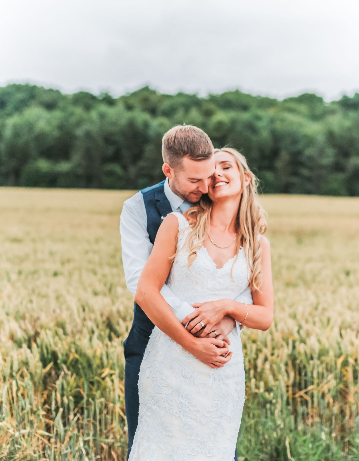 Intimate countryside wedding portrait amidst golden wheat field.