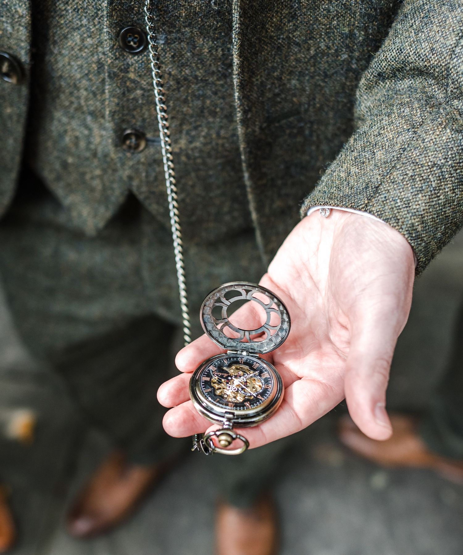 Close-up of hands holding an antique pocket watch with intricate details.