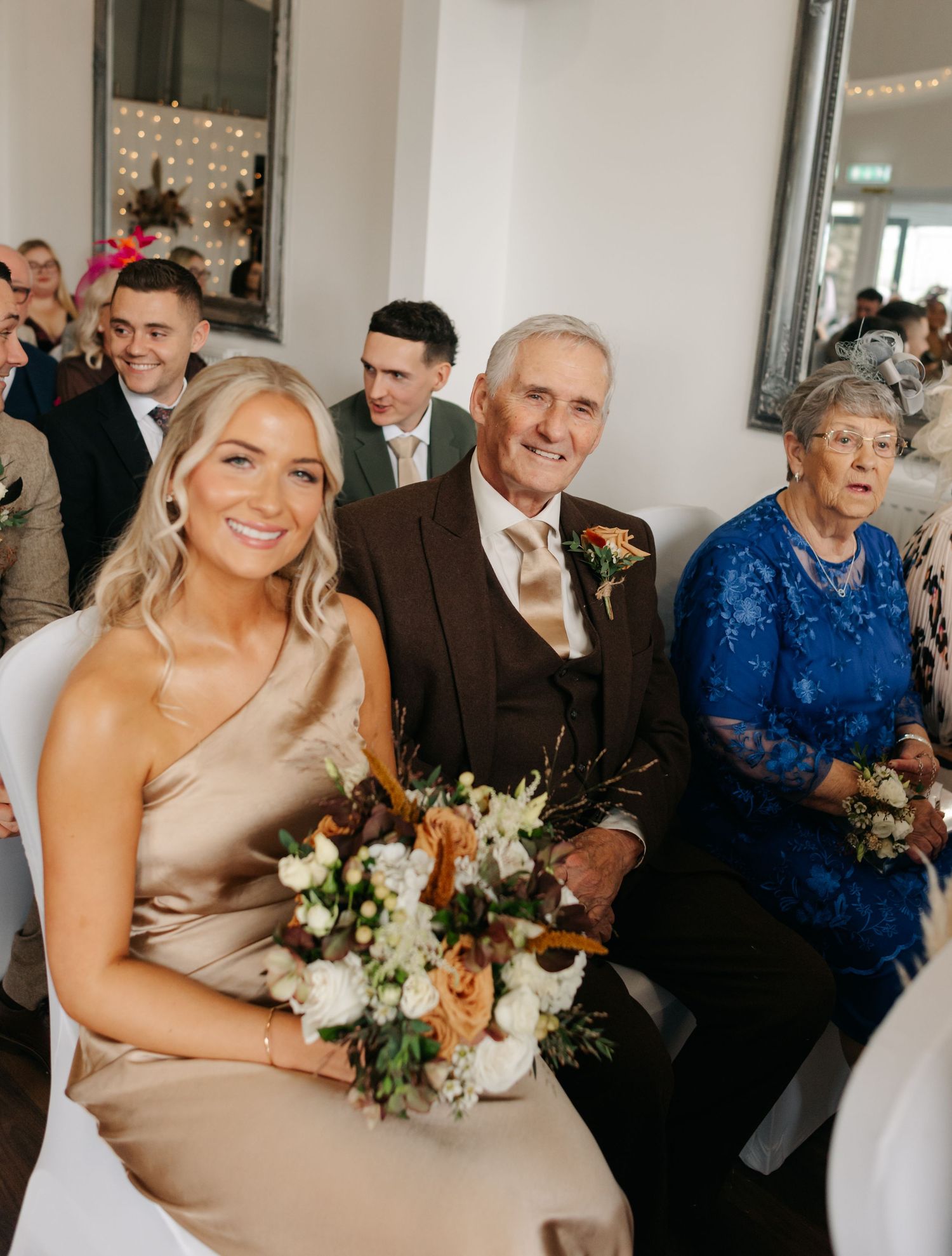 Wedding party members gather for candid celebration photos in an indoor venue.
