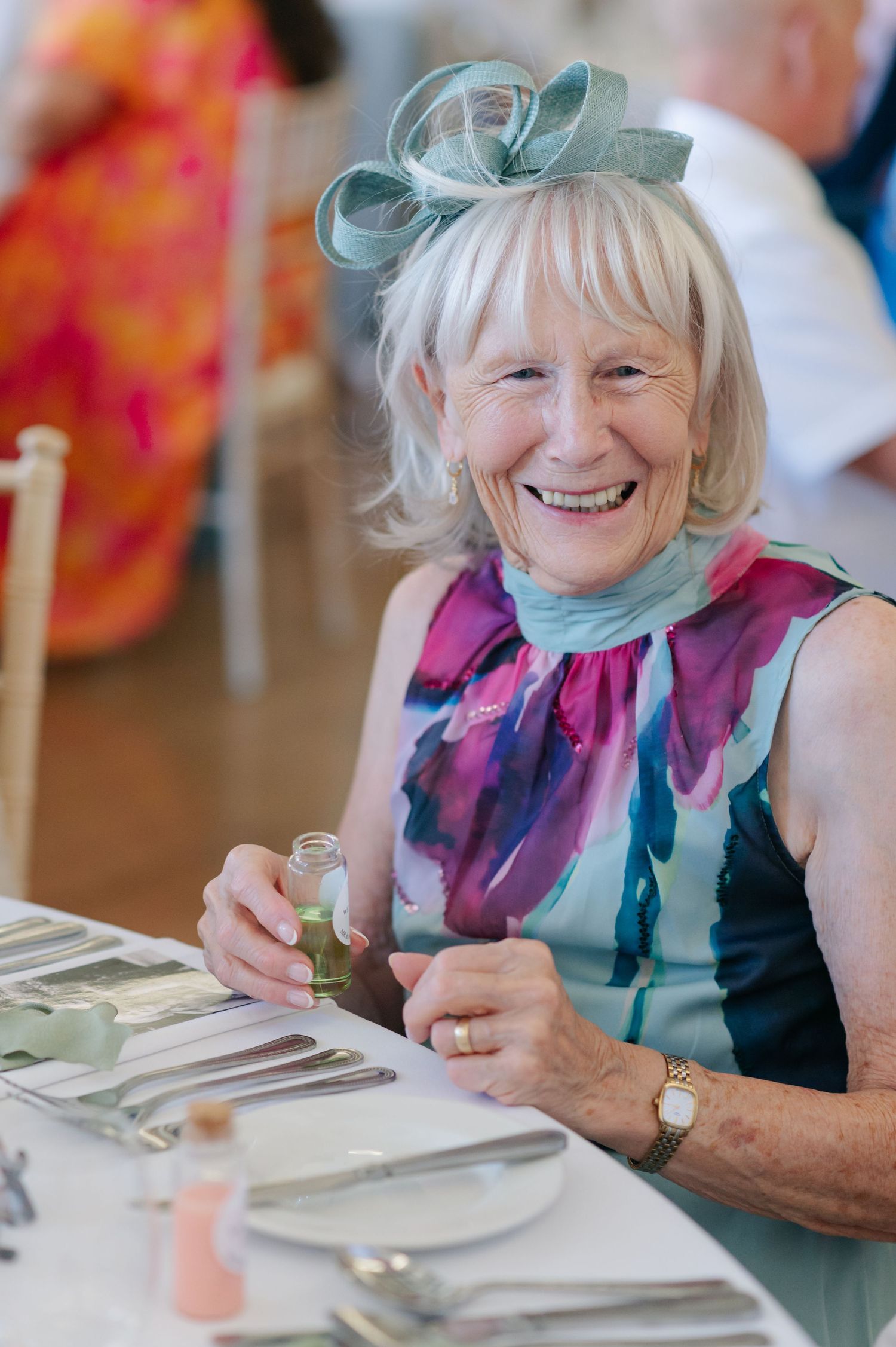 Guest enjoying the wedding reception dinner with a bright smile and festive attire.