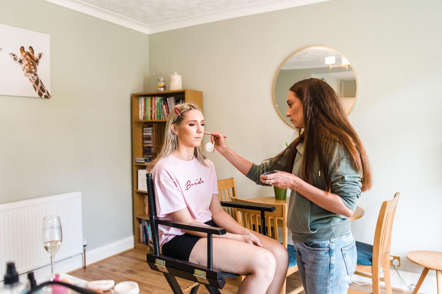 Behind the scenes preparation with makeup application in casual home setting.