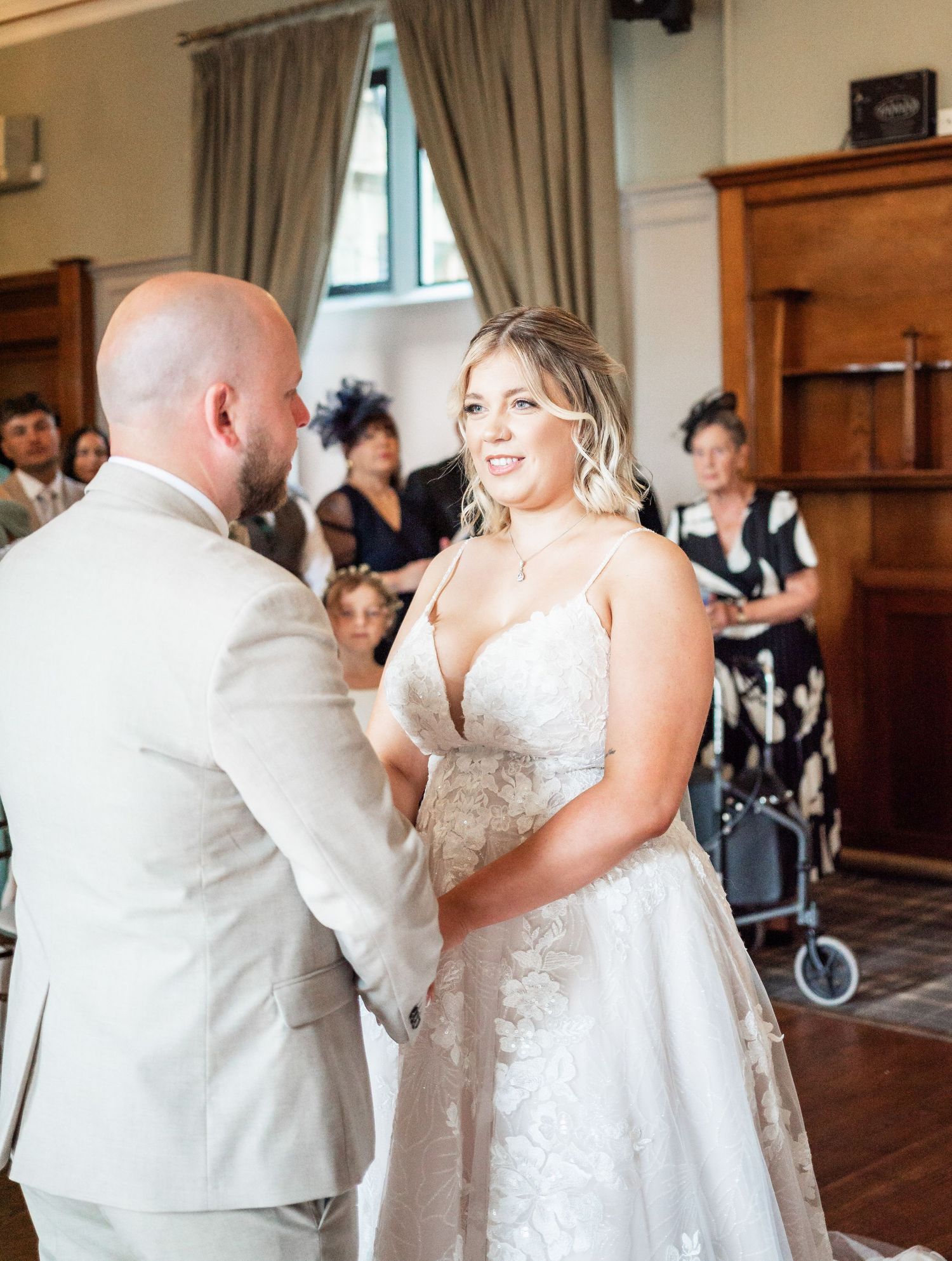 Wedding ceremony moment in elegant indoor venue with wooden details.