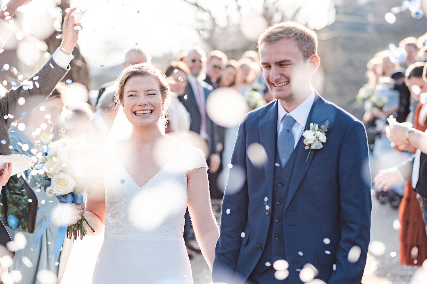 Joyful wedding celebration outdoors with sunlight and confetti creating a magical atmosphere.