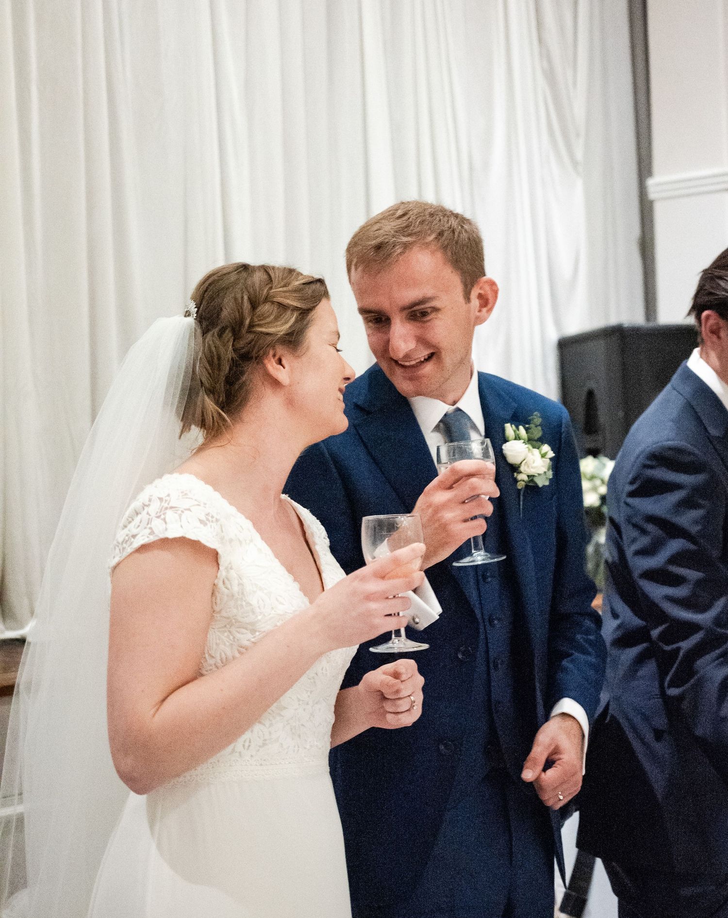 Newlyweds sharing champagne and laughter during their wedding reception.
