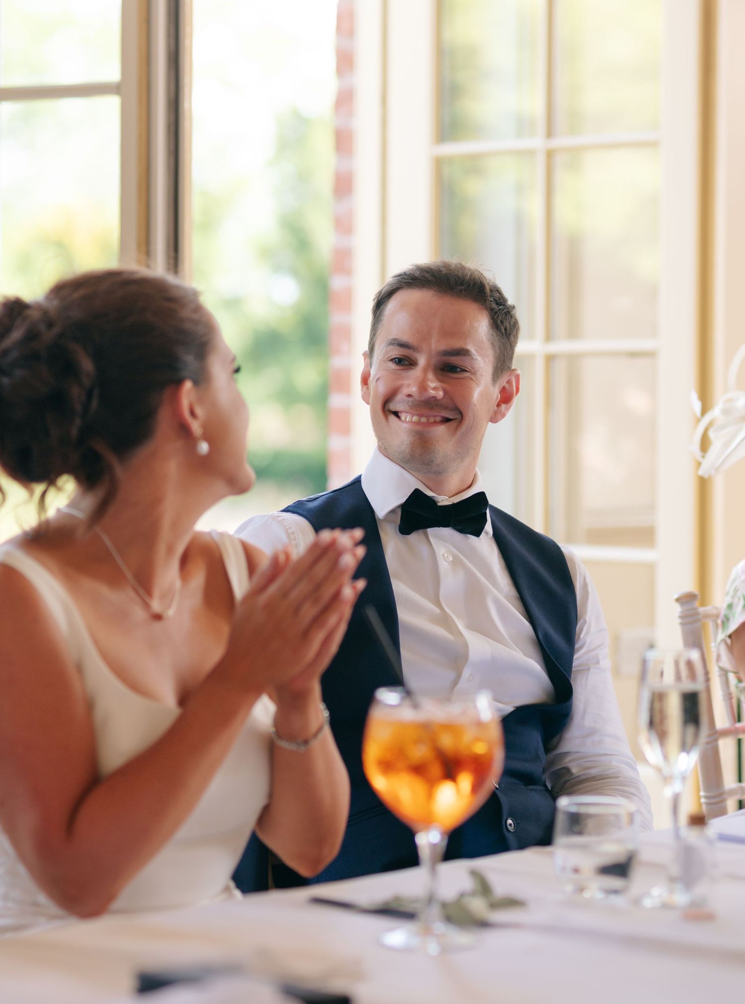 Wedding reception scene with guests dining and sharing laughter.