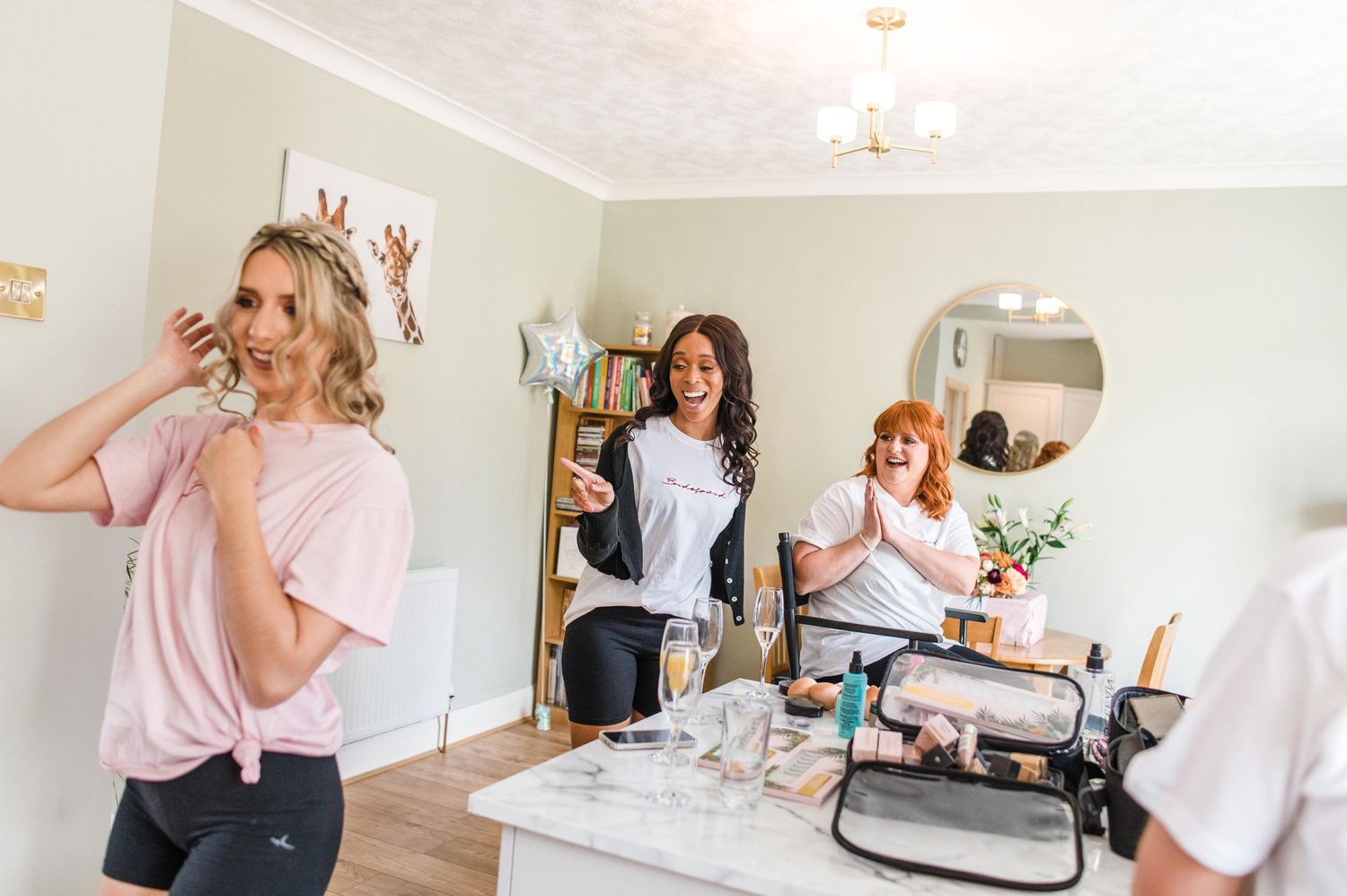 Wedding morning preparations with friends getting ready in bright room.