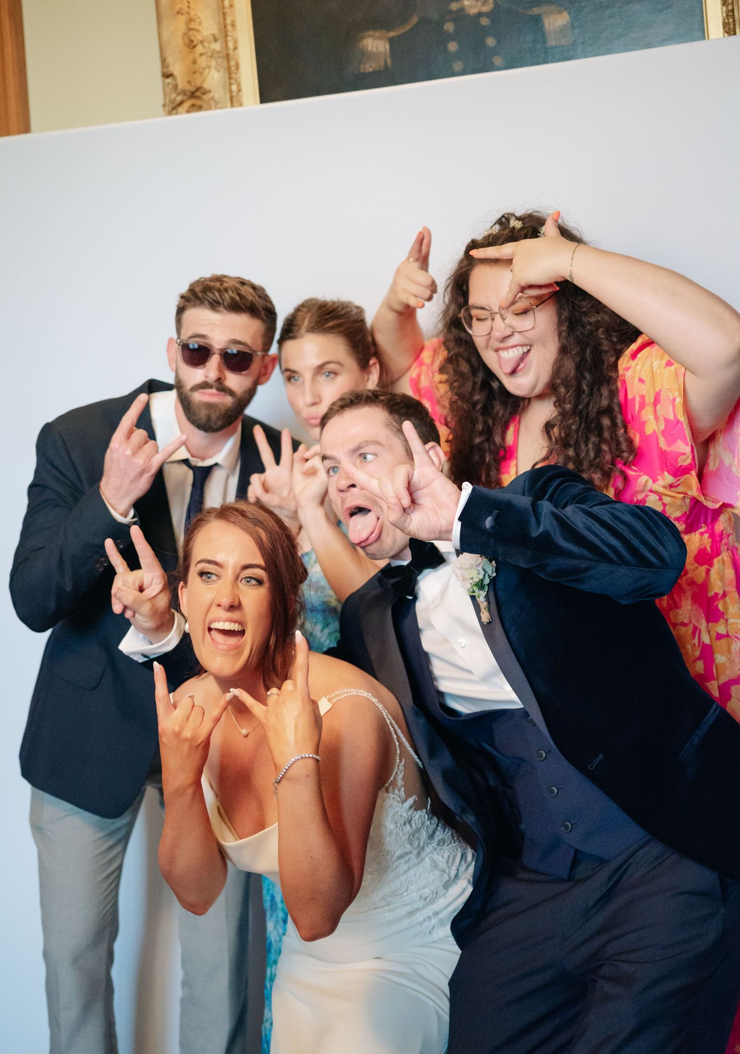 Wedding party makes silly faces and poses for fun group photo.