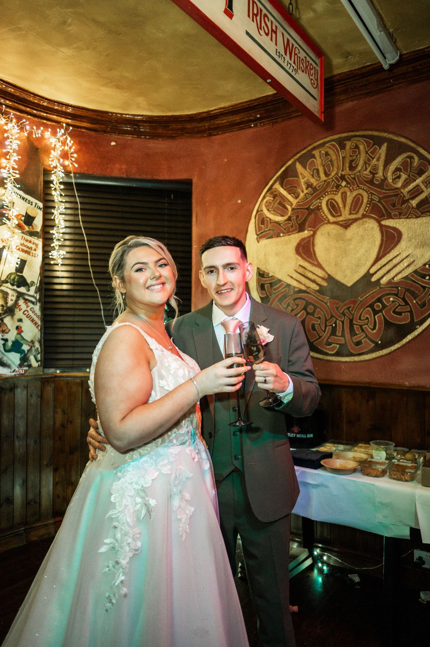 Wedding celebration at Irish pub with Claddagh sign and festive decorations.