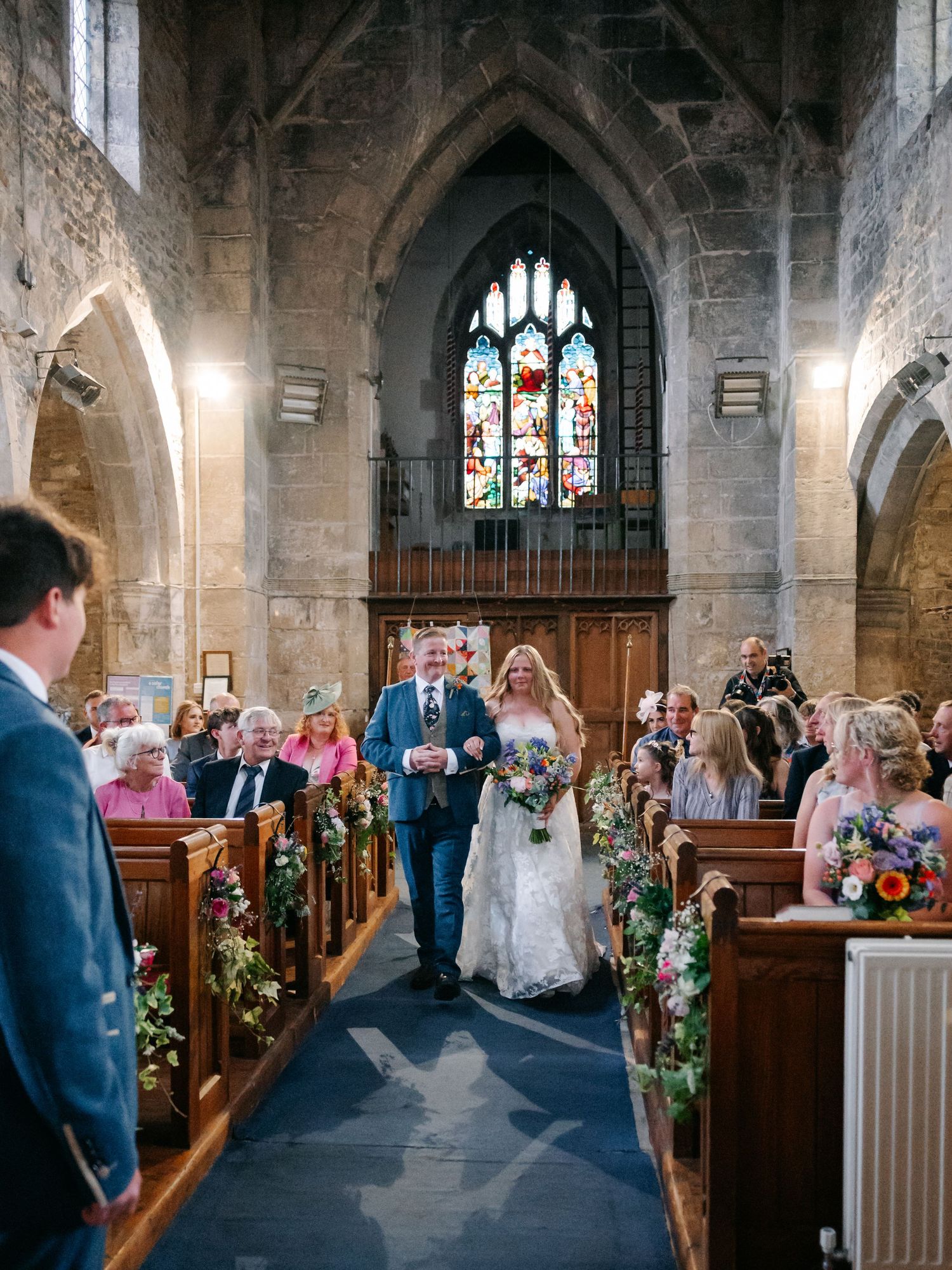 Beautiful stone church interior decorated with floral arrangements for a wedding ceremony.