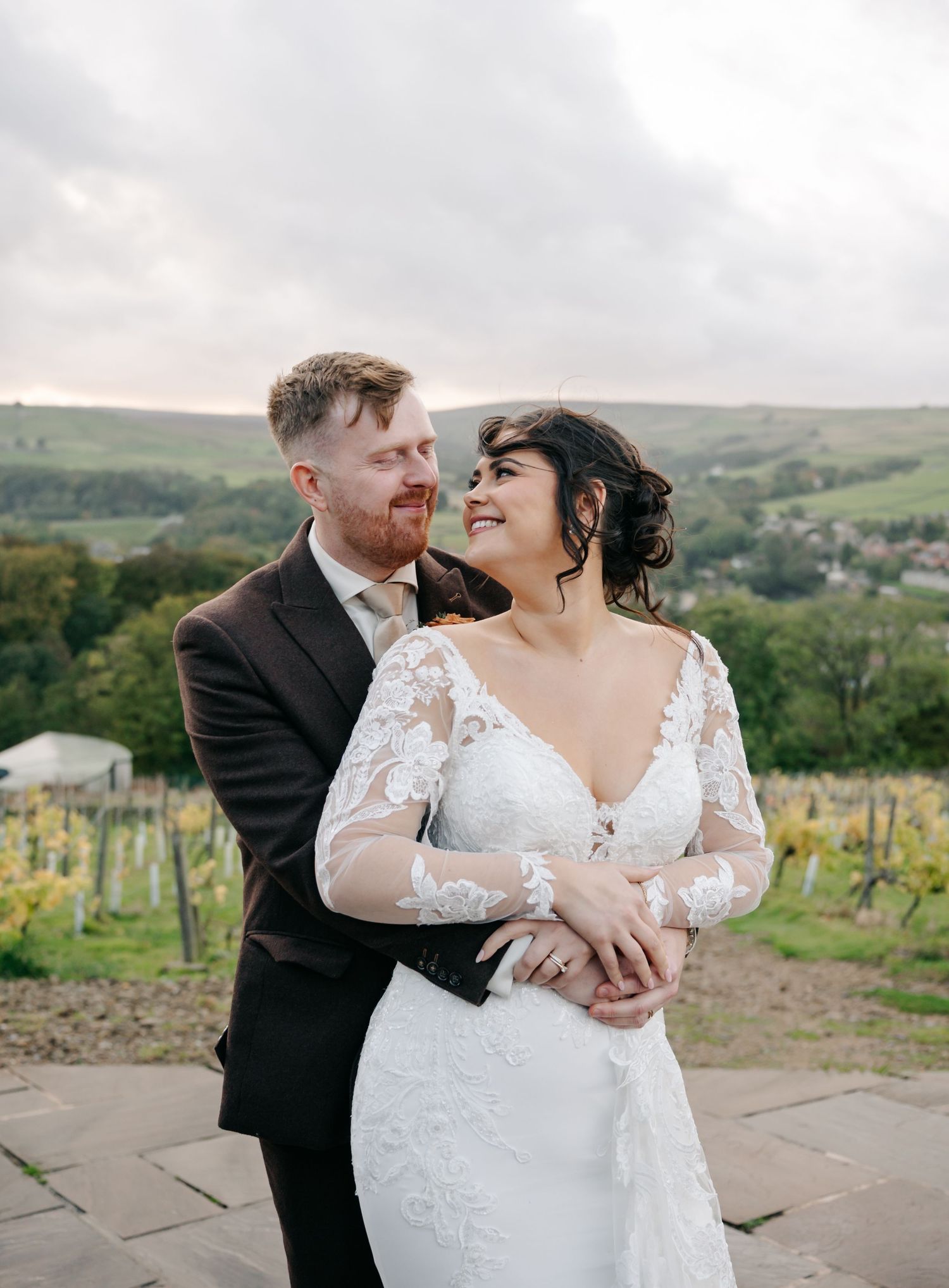 Romantic outdoor wedding portrait with rolling hills and countryside in the background.