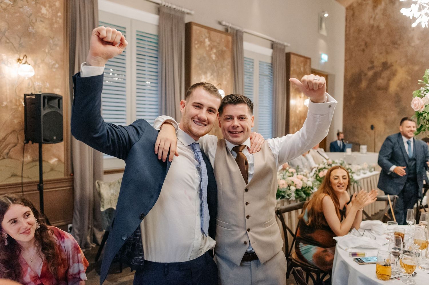 Wedding reception guests enjoying drinks and dancing in an elegant vintage-style venue.