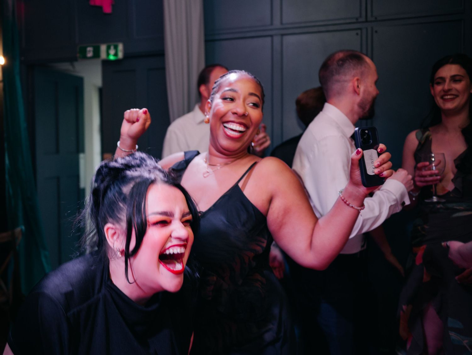 Party guests dancing and celebrating at a dimly lit evening reception.