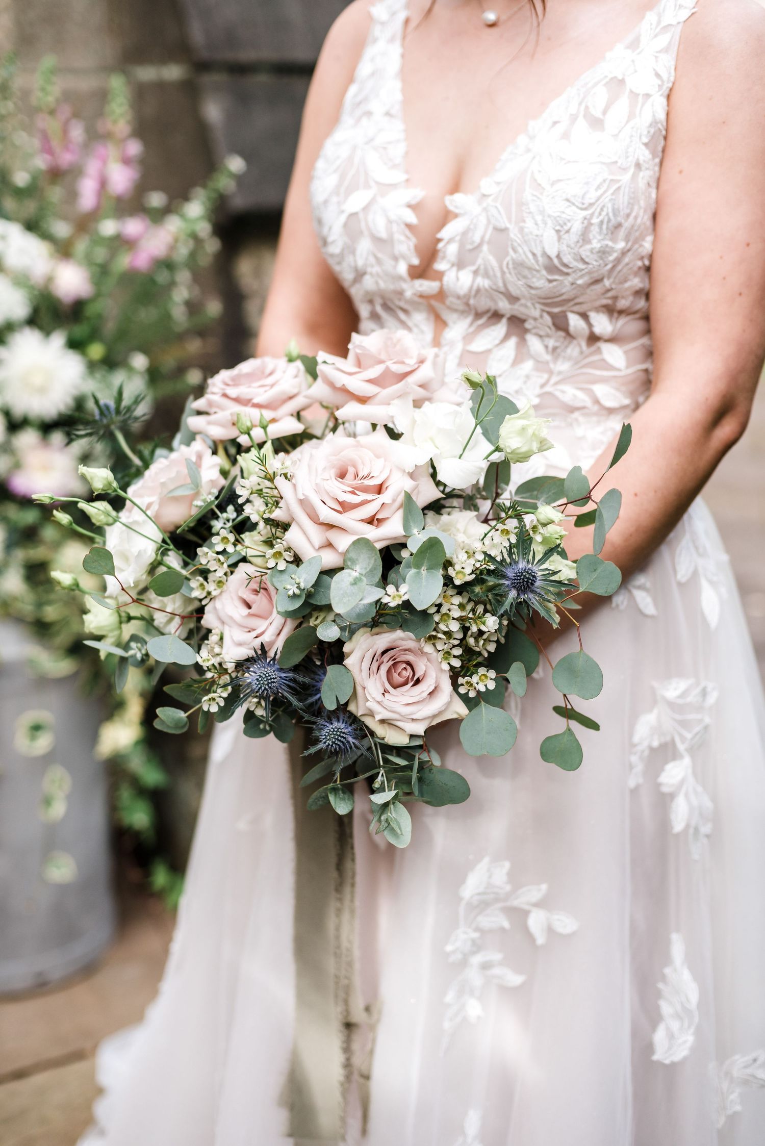 An elegant bridal bouquet featuring blush roses, white flowers and eucalyptus leaves.