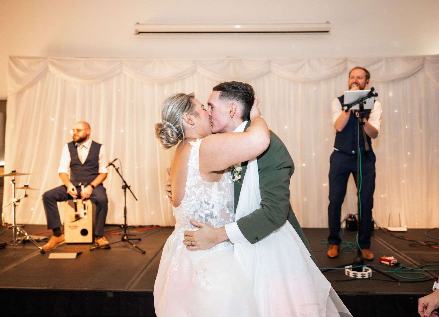 Band performs on stage while couple shares intimate moment during reception.