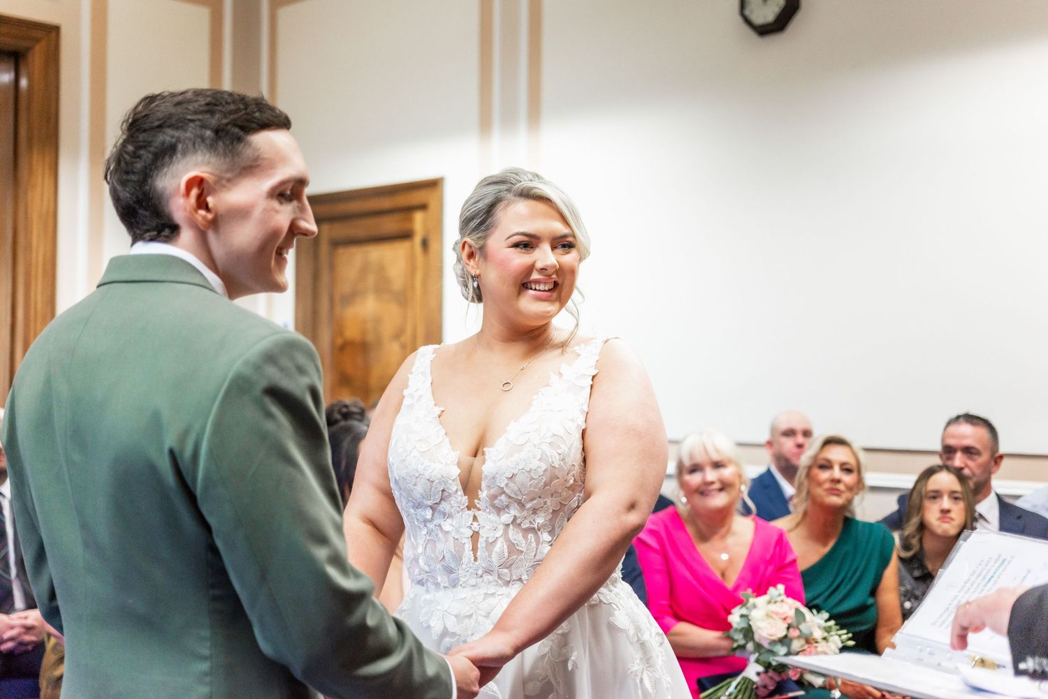 Joyful wedding ceremony moment captured in a bright indoor venue with wooden details.