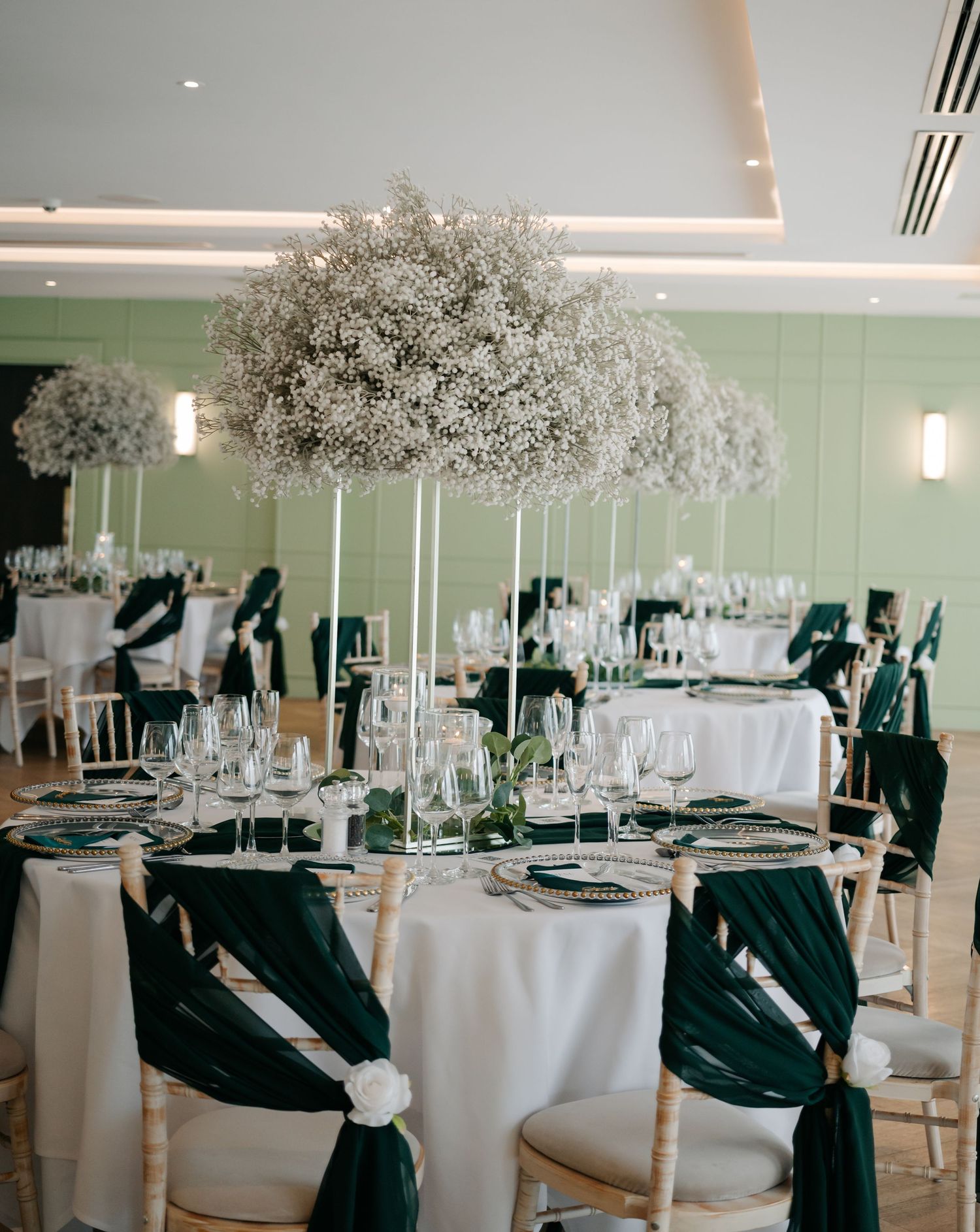Elegant wedding reception venue with white tables and floral centerpieces.