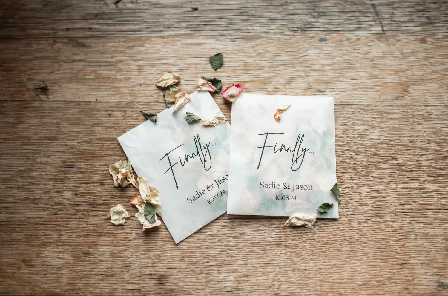 Two wedding invitations with 'Finally' text displayed on rustic wooden background.